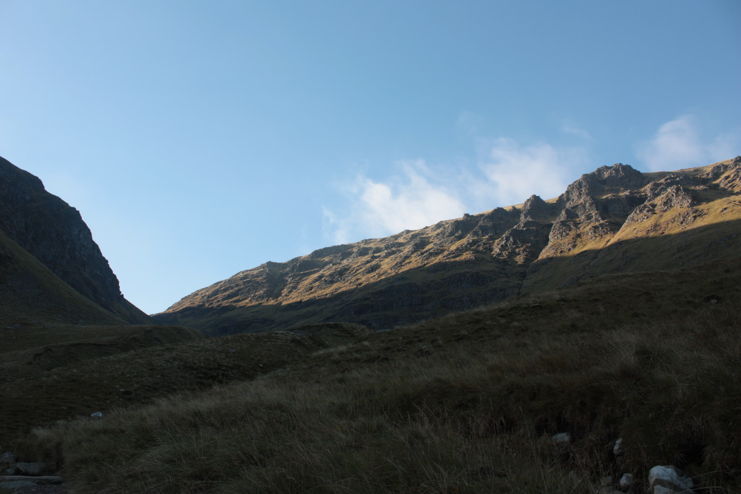 Low sun on the crags of Stob Poite Coire Àrdair, seen from the shadowed corrie below.