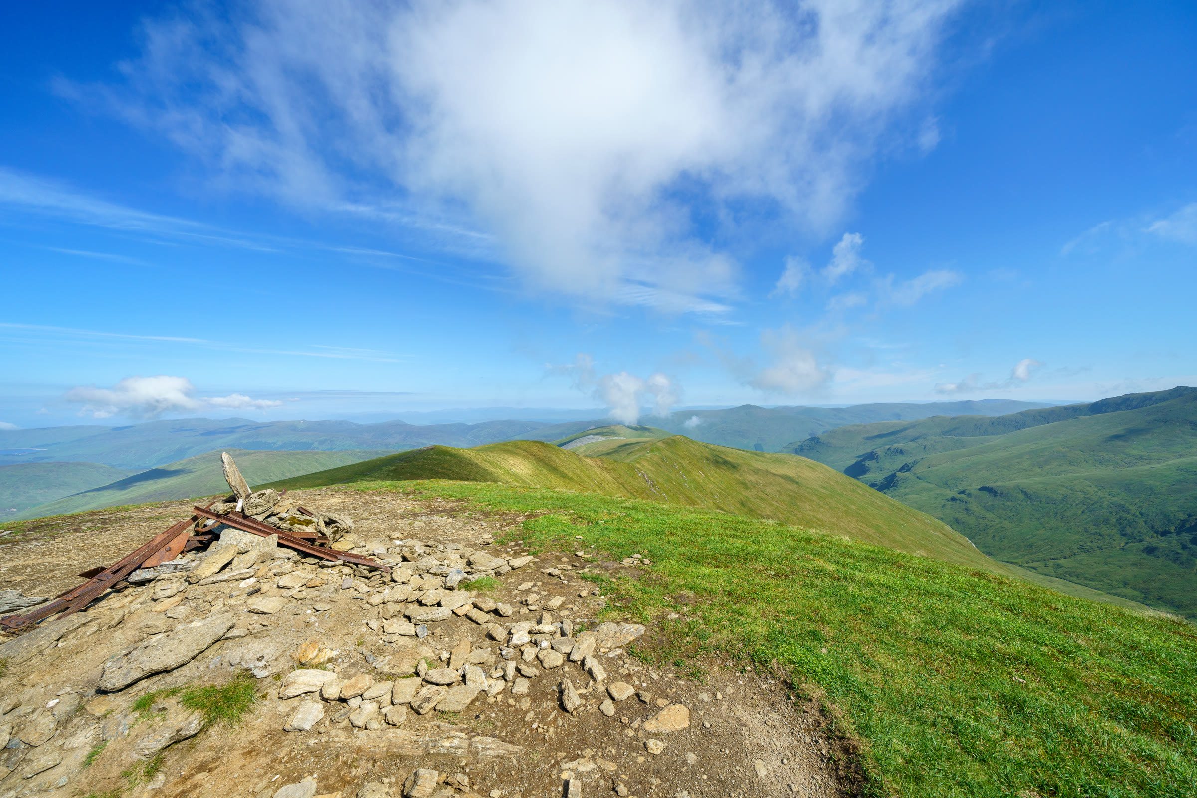 The summit of Meall Corranaich, old iron fence posts beside the path, with Meall a' Choire Lèith along the ridge.