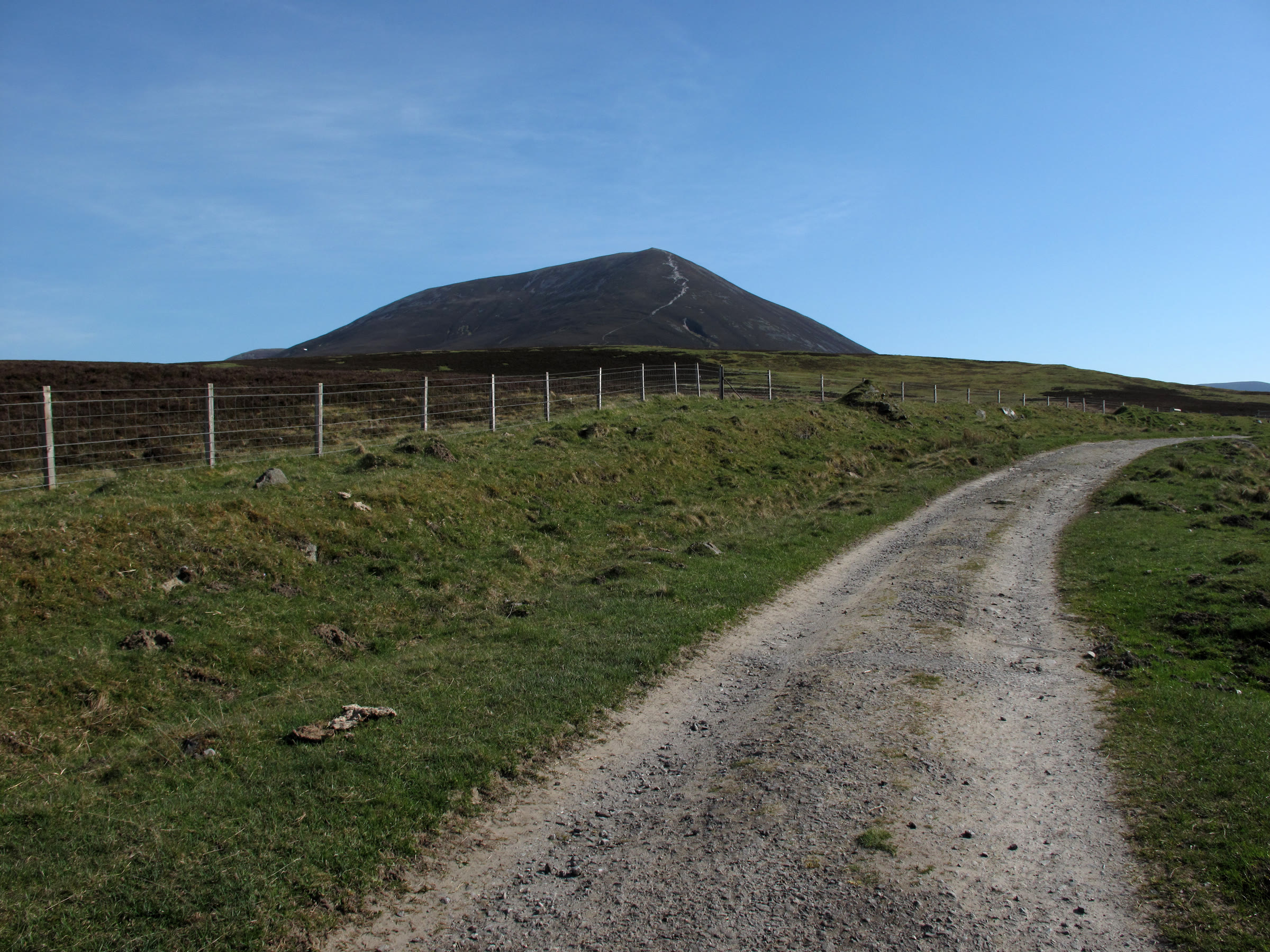 A stony track climbing towards the Beinn a' Ghlò hills, the nearest a dark cone with a path worn up it.