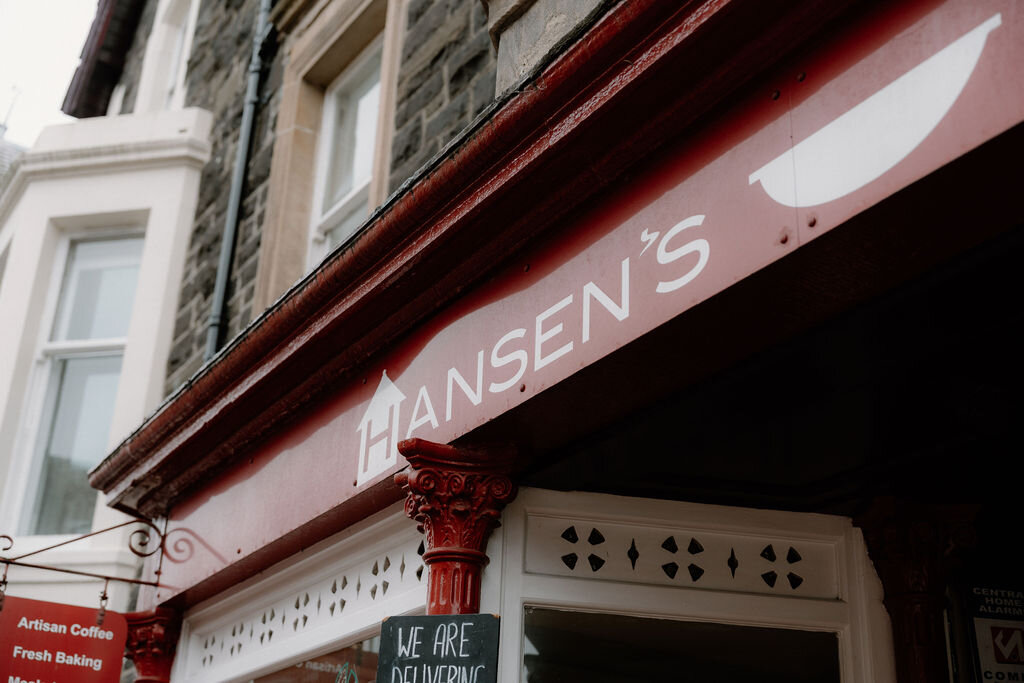 A carved shell motif tops Hansen's sign above its 'Artisan Coffee, Fresh Baking' lettering.