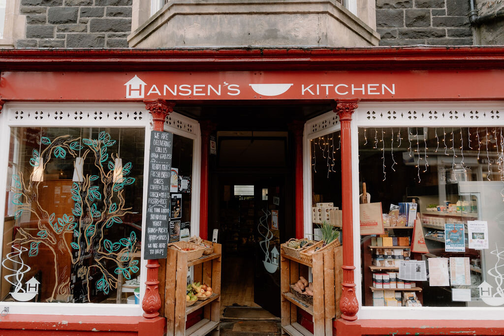 Hand-painted vines curl across the window of Hansen's Kitchen shopfront.