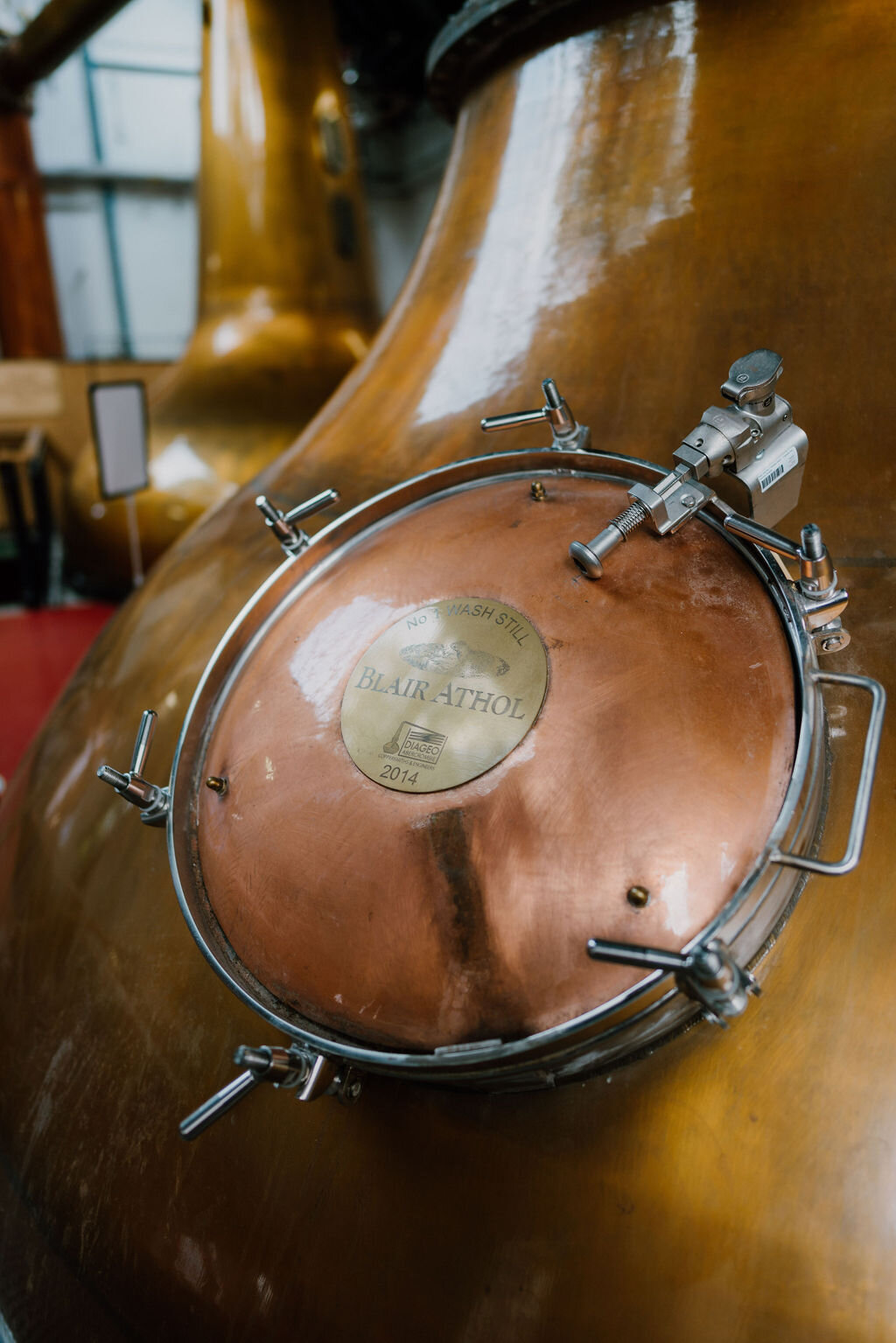 A copper still's hatch is stamped with a plaque reading 'BLAIR ATHOL, NO. 1 WASH STILL, 2014'.
