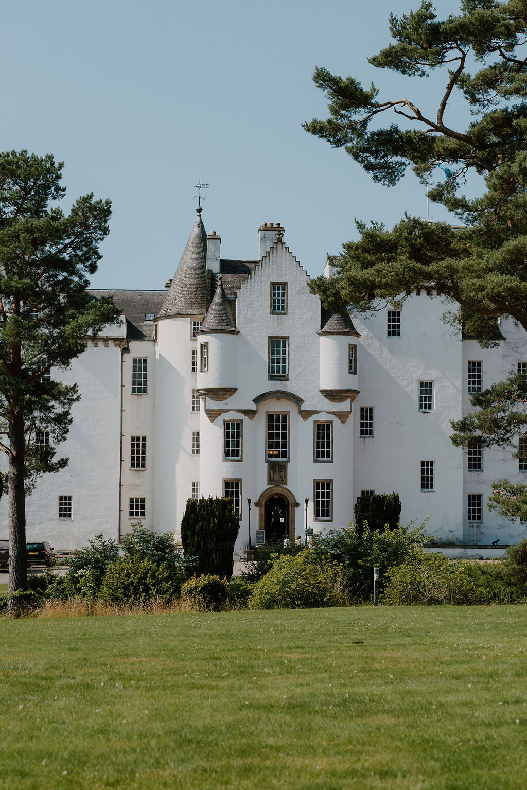 Blair Castle's crow-stepped gables and turrets rise above hedges and a gravel drive.