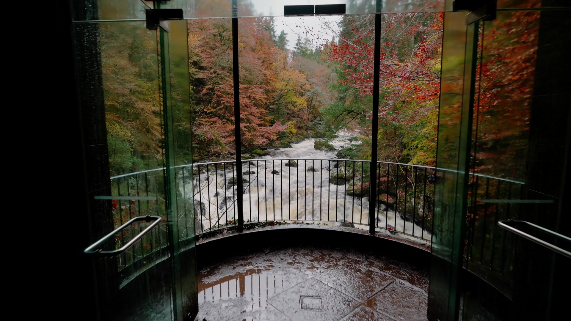 Ossian's Hall's round stone pavilion carved MVM above its door, an autumn woodland path leading to it