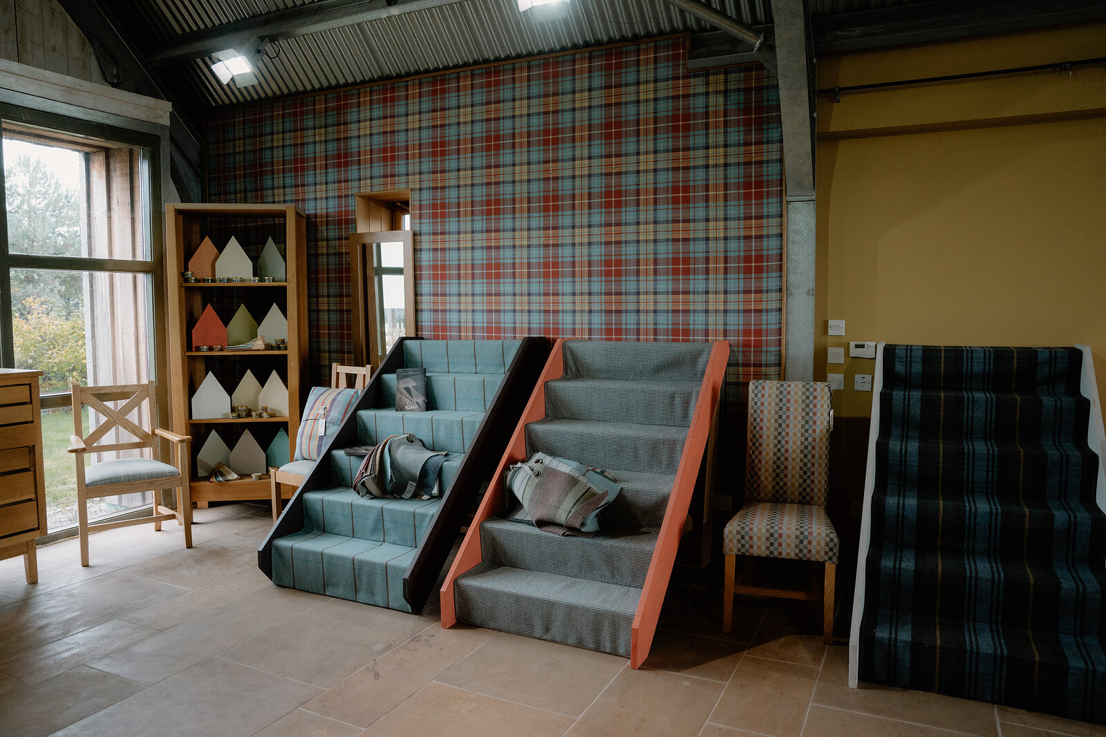 Tartan-upholstered display steps stand before a red-and-blue plaid feature wall at ANTA.