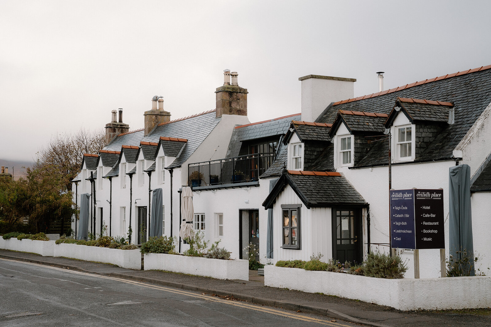 White-harled buildings with black slate roofs and dormer windows make up The Ceilidh Place in Ross and Cromarty.