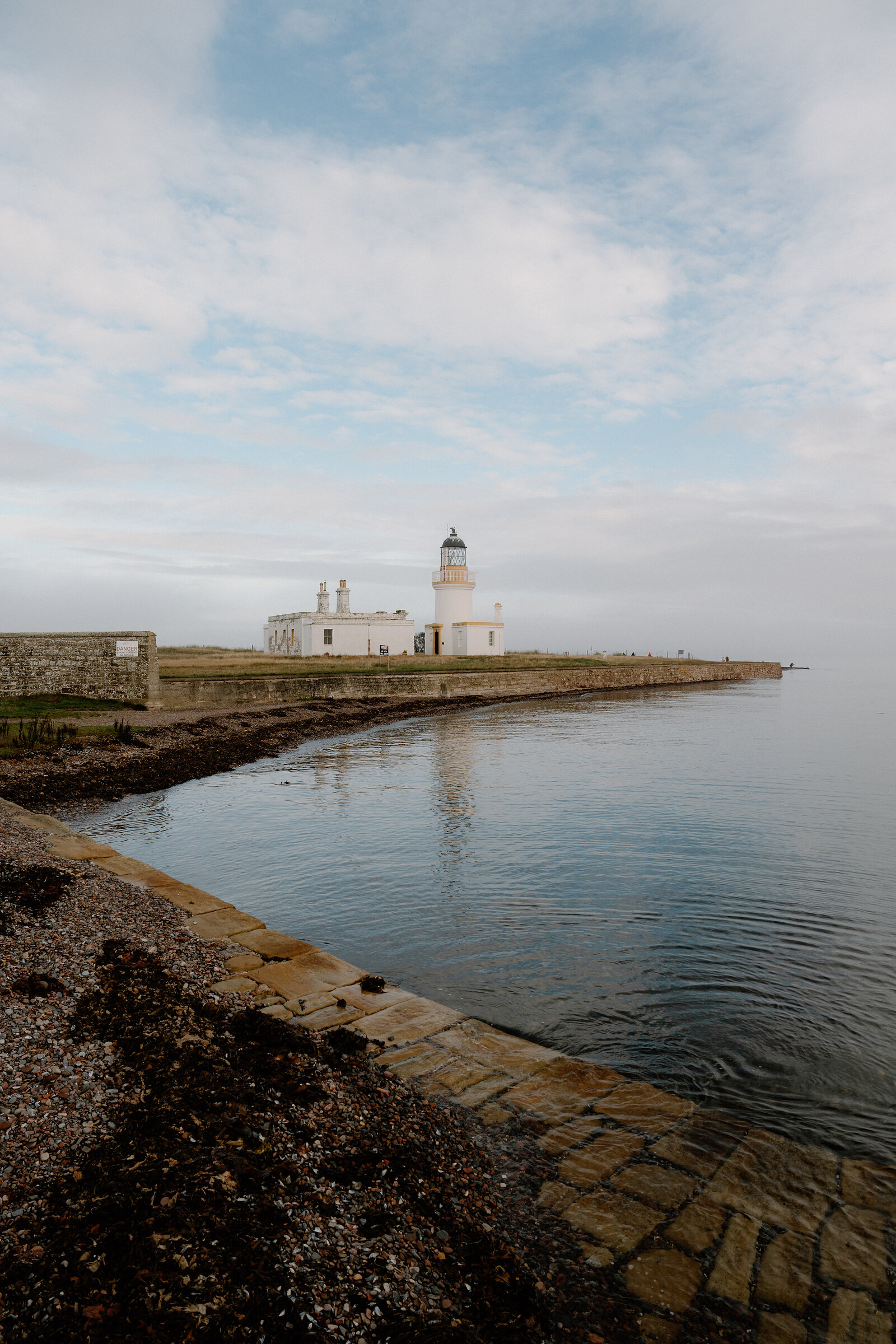 A gravel track leads across open grassland to Chanonry Point Lighthouse in Ross and Cromarty.