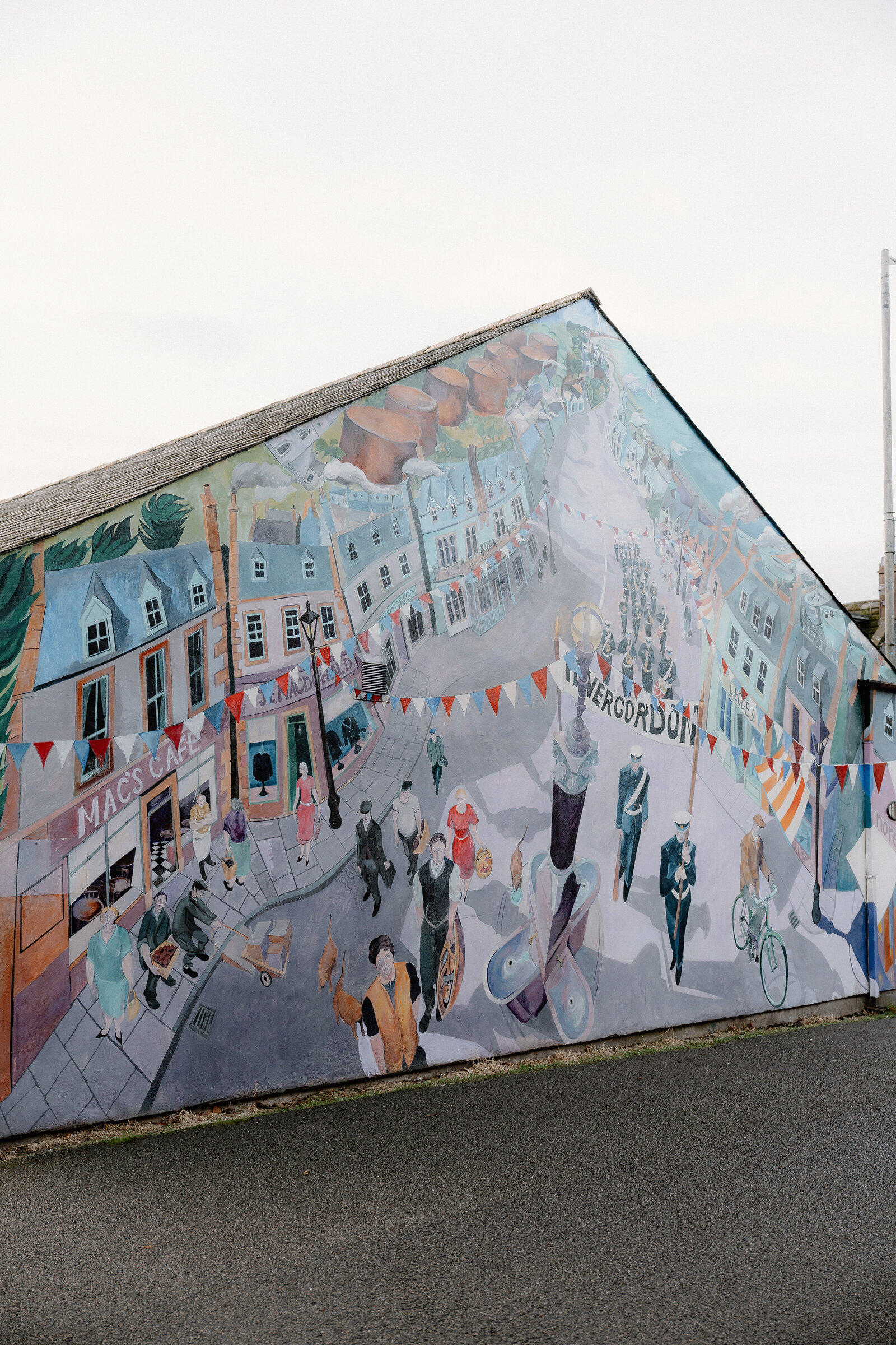 A mural depicts a bustling 1920s street scene with bunting on a gable end in Invergordon, Ross and Cromarty.