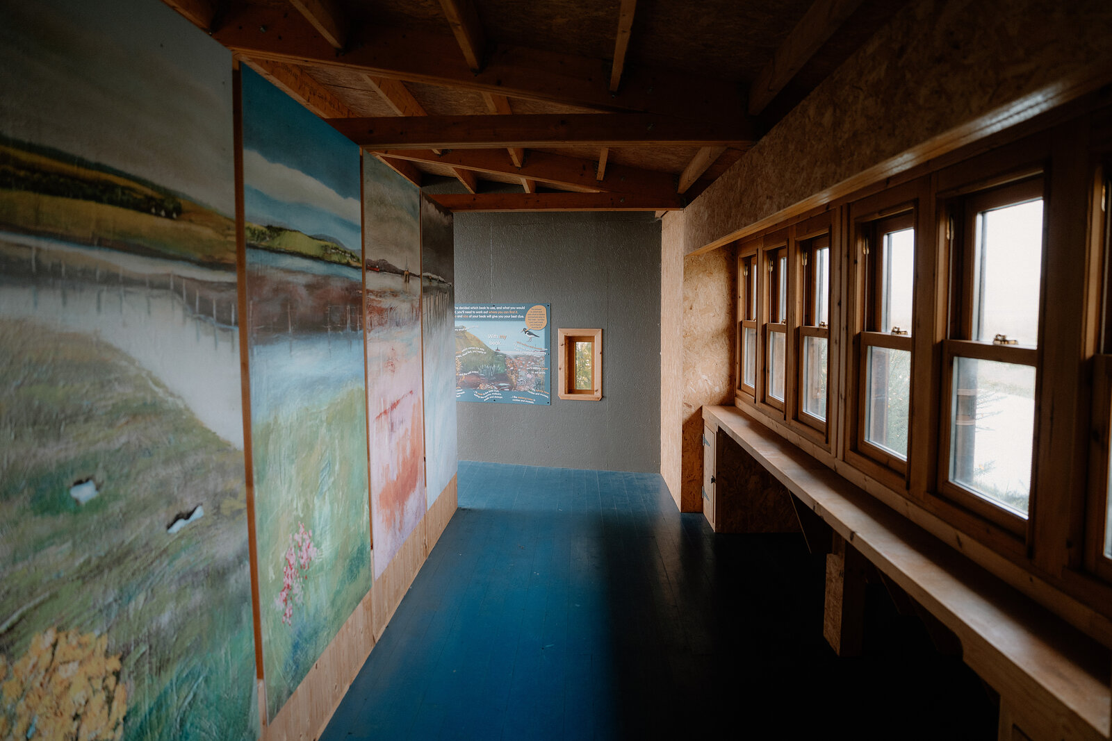 Painted wetland murals line a corridor inside a wildlife hide in Ross and Cromarty.