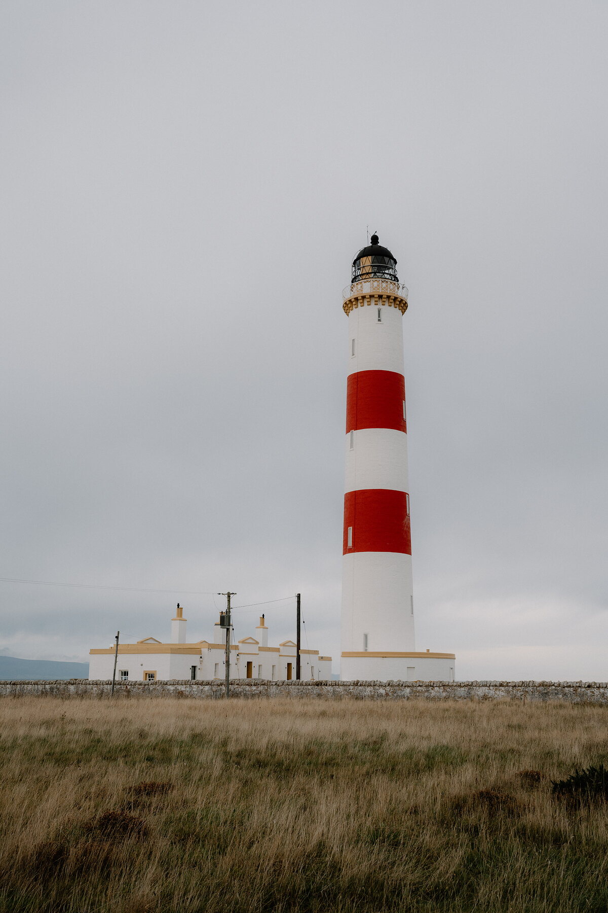 Tarbat Ness Lighthouse's red and white bands rise above grassland in Ross and Cromarty.
