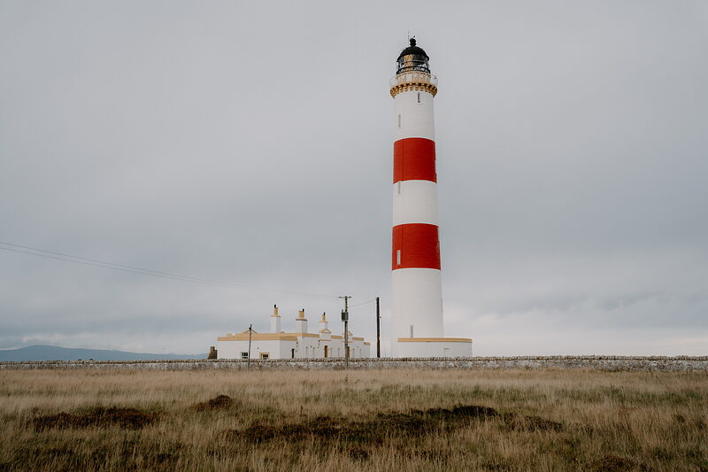 Tarbat Ness Lighthouse rises above open grassland beside its keeper's cottages in Ross and Cromarty.