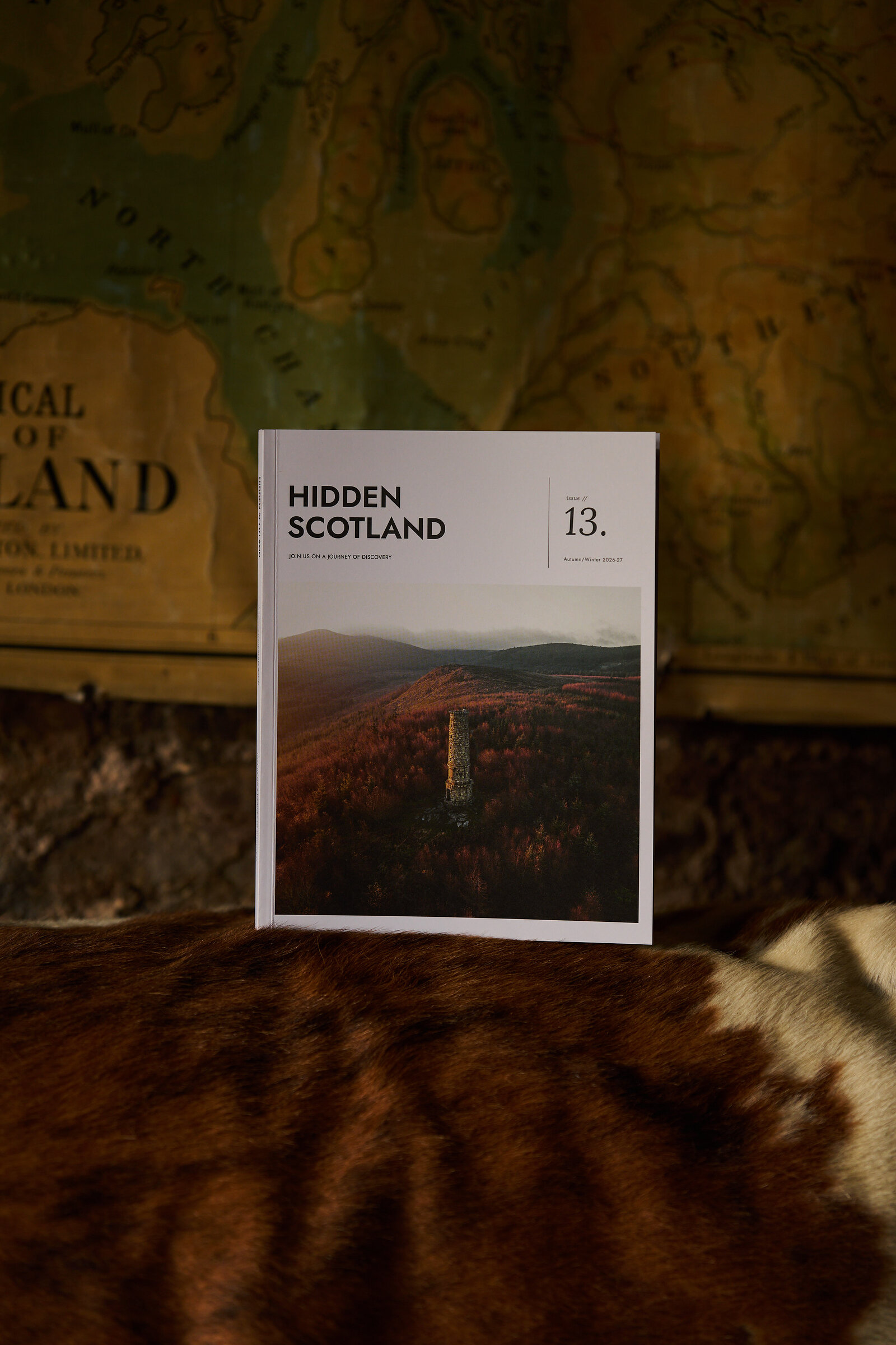 Issue 13 on a cowhide armchair under an old map of Scotland