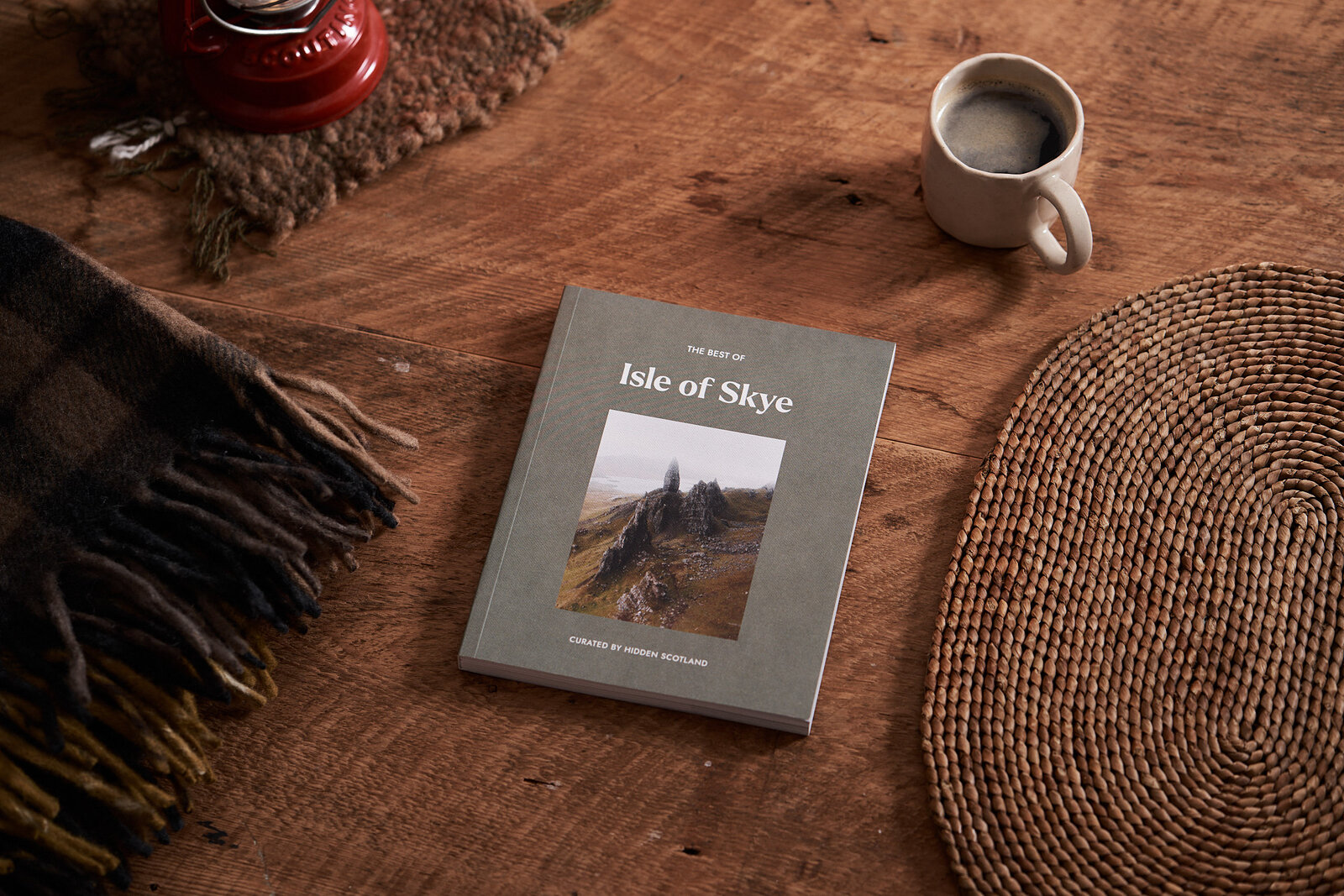 The Best of Skye on a wooden table beside a lantern and a mug