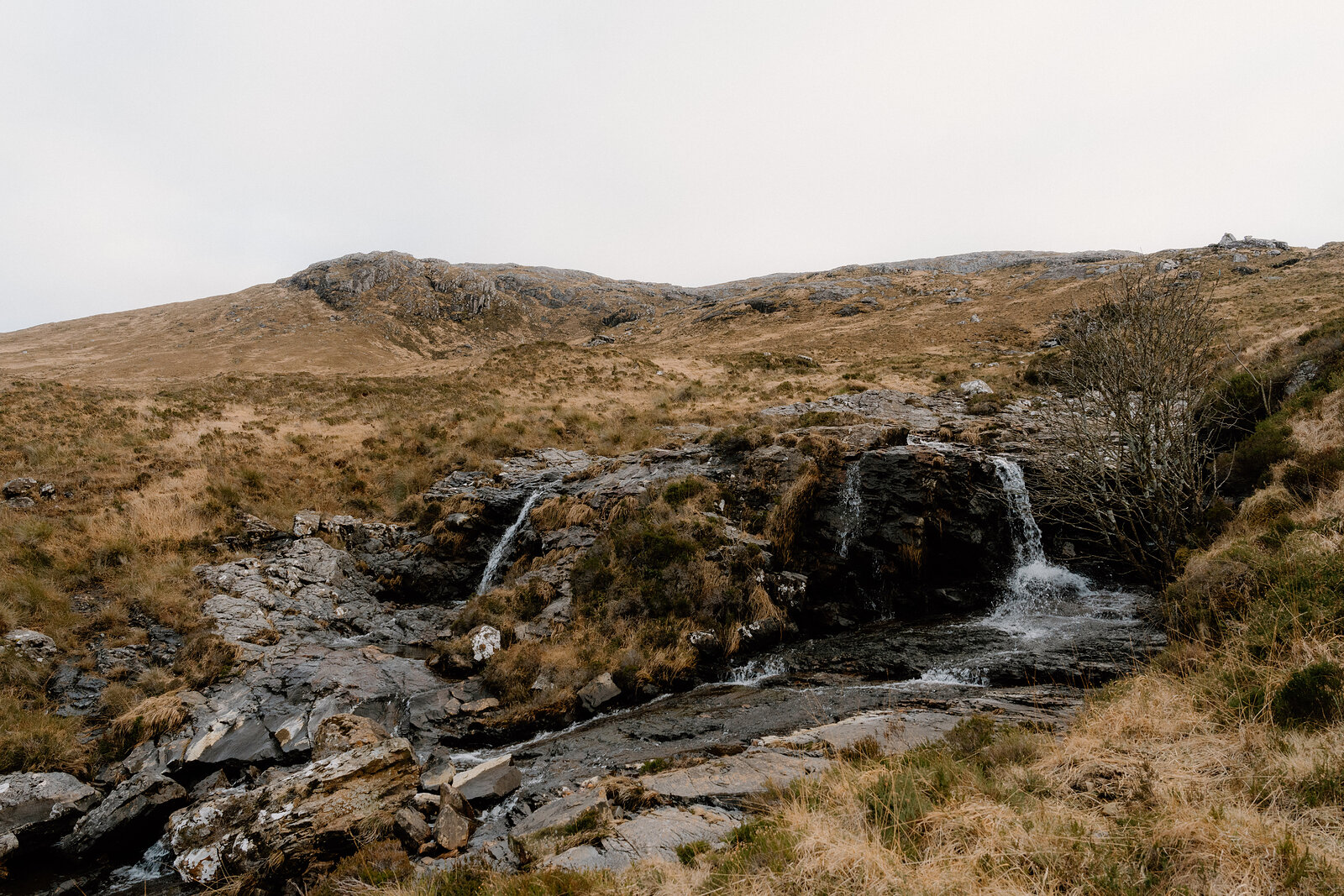 A small waterfall tumbles over rock on open moorland on the Isle of Rum.