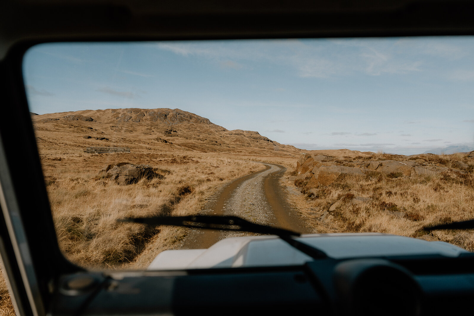 A jagged mountain peak rises above rocky moorland on the Isle of Rum.
