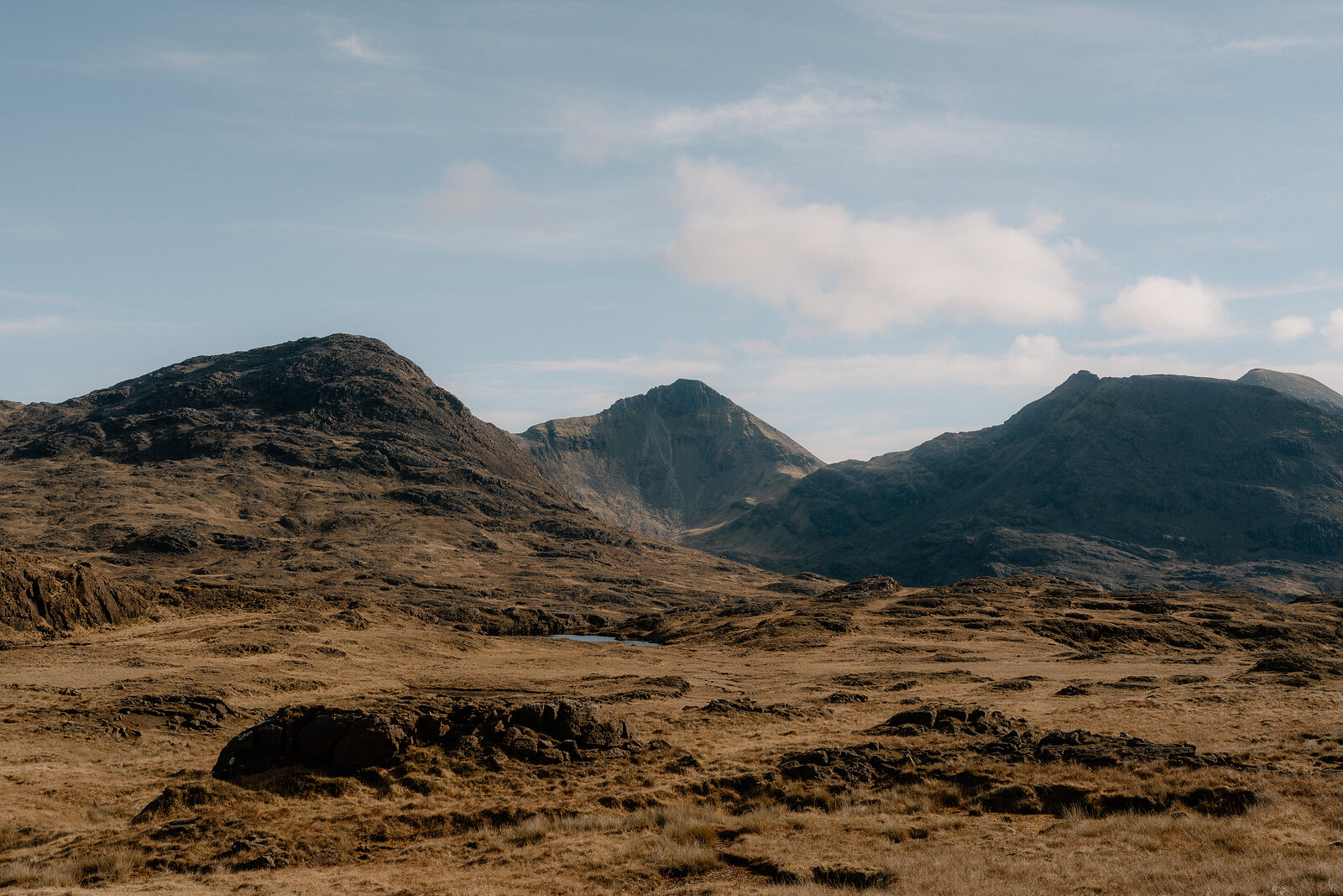 Jagged mountain peaks rise above golden moorland on the Isle of Rum.