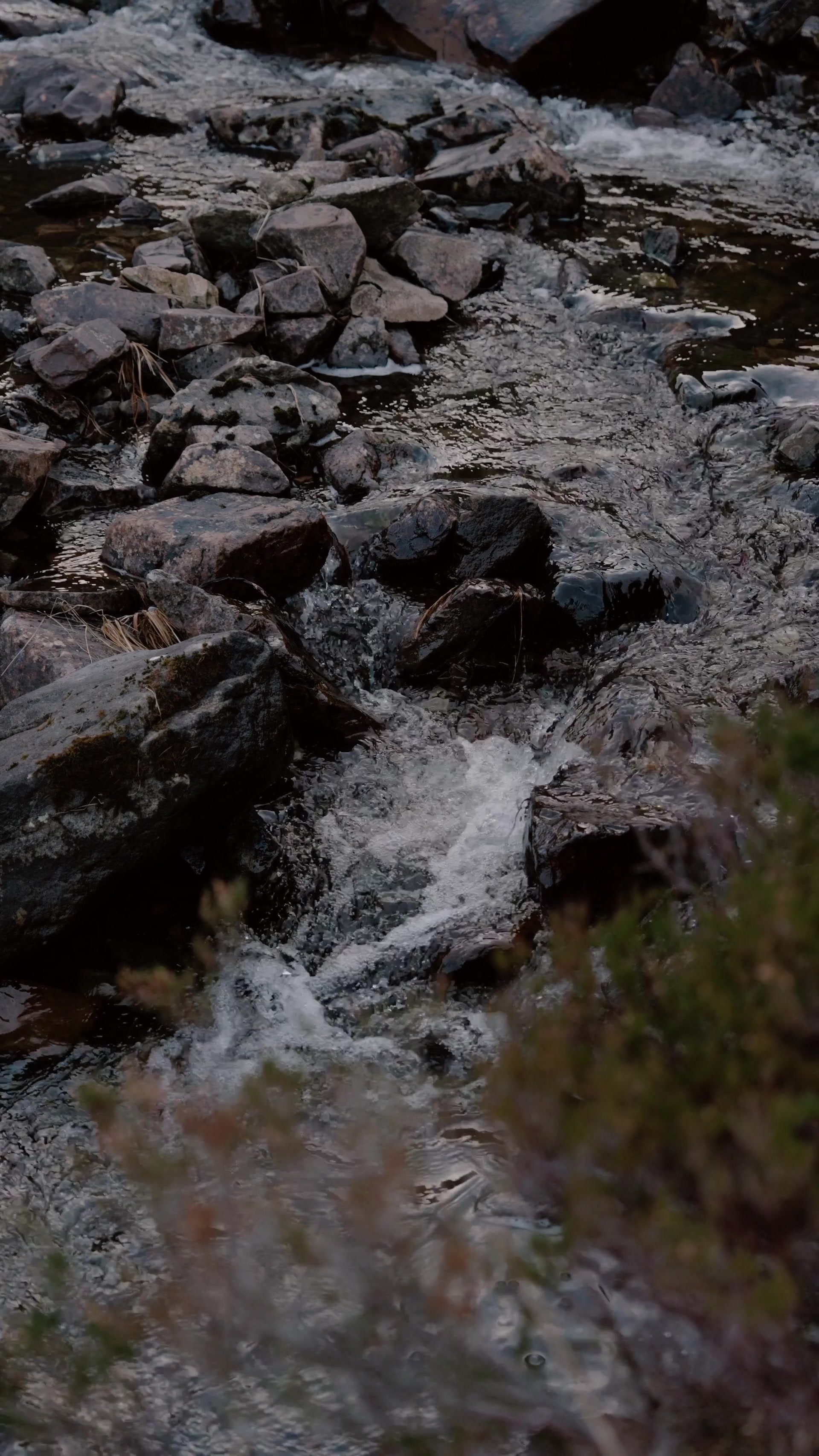 a close view of a rocky burn tumbling over dark stones on Rum