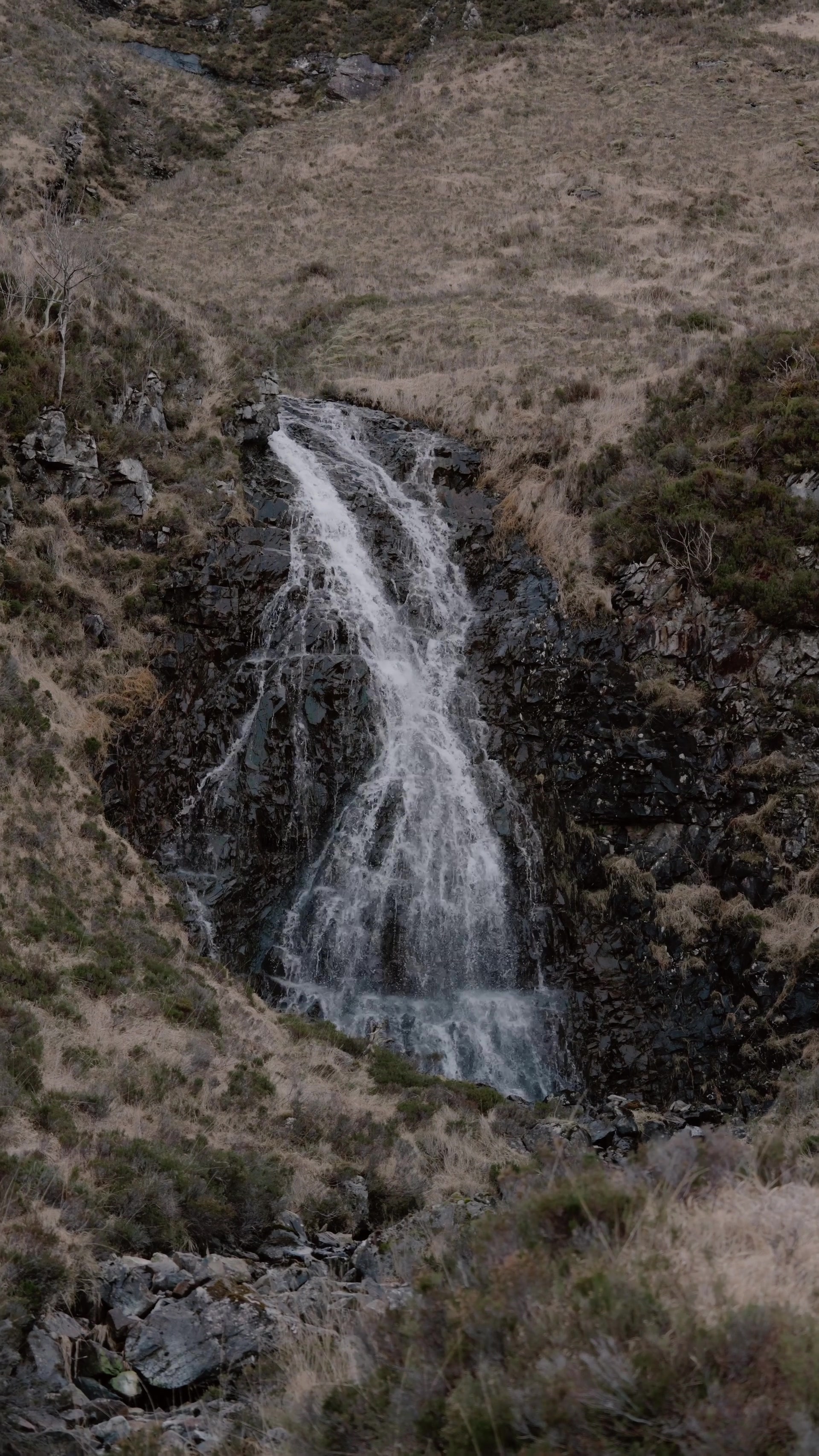 a waterfall cascading through a narrow rocky gully on a dry hillside on Rum