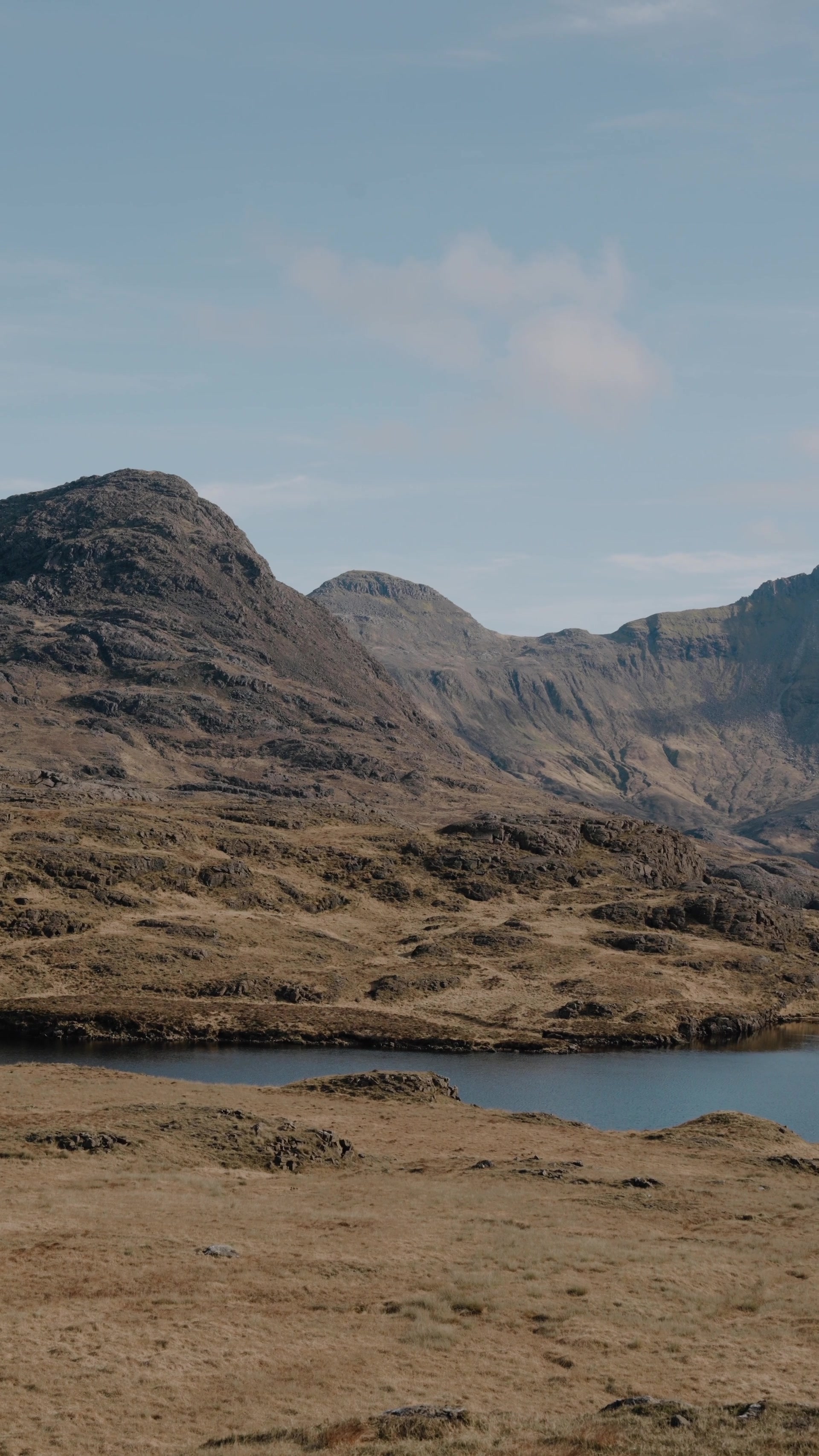 twin rocky summits rising above a moorland loch, cliffs falling away to the right