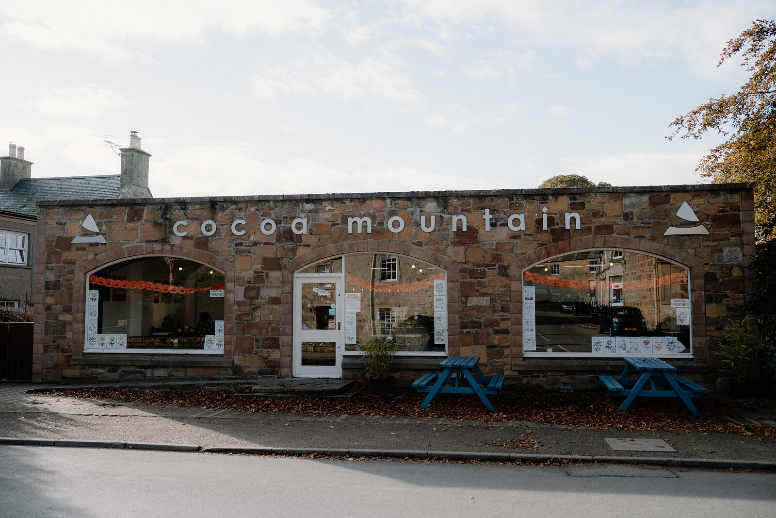 Cocoa Mountain's stone-fronted shop overlooks a pair of blue picnic tables on the street.