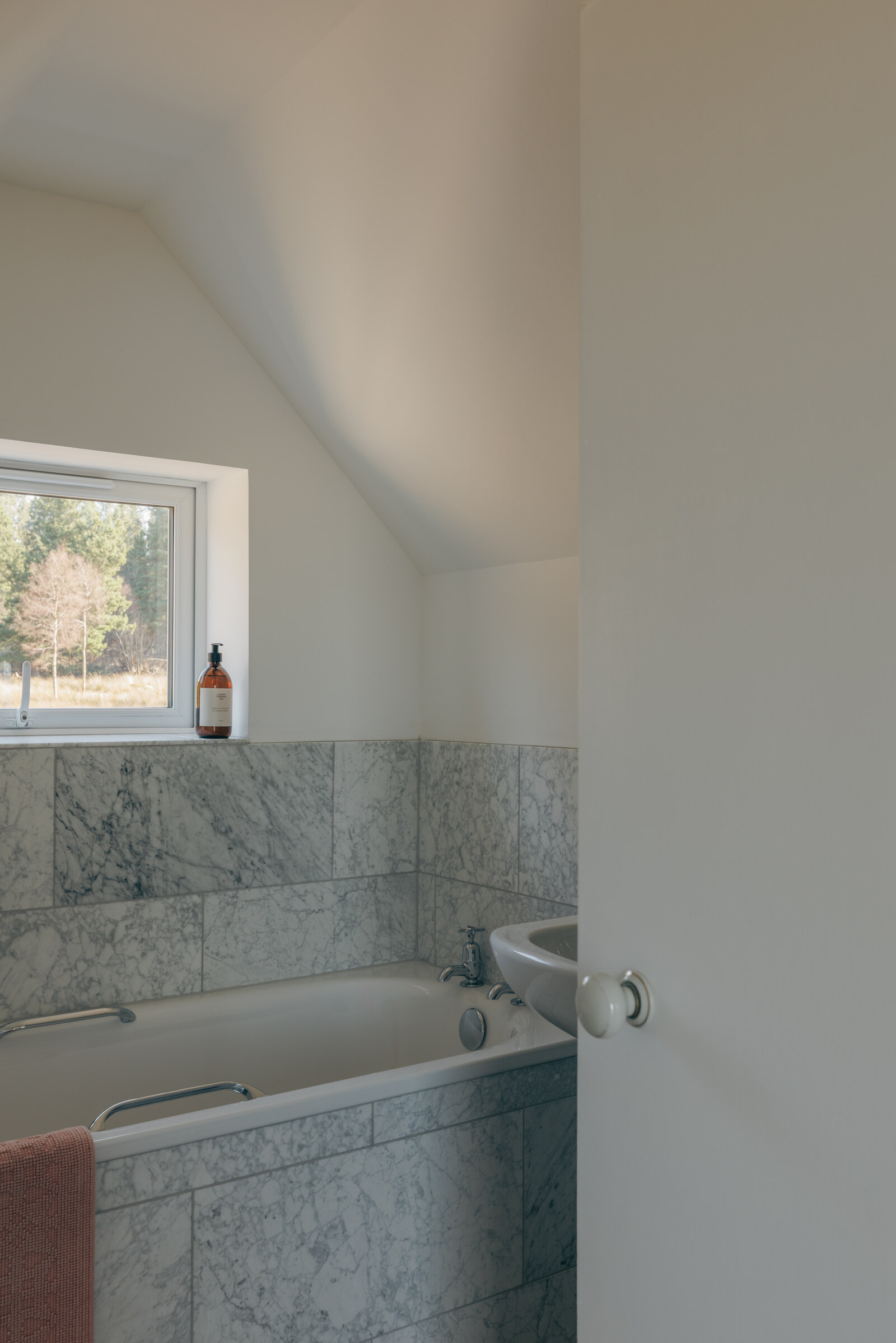 The bath beneath a small window in Rhuroin’s bathroom.