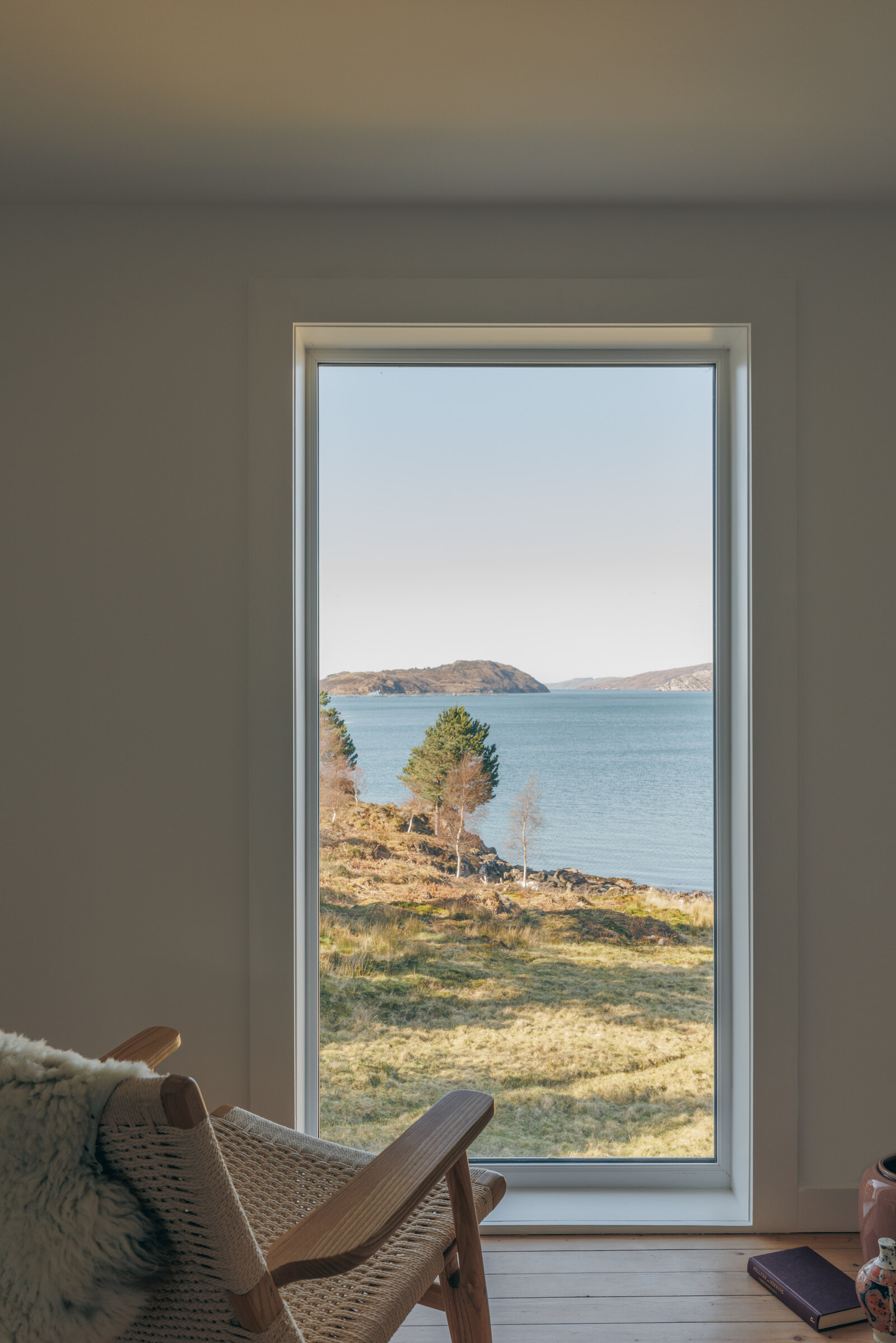 Rhuroin’s tall landing window looks out over the loch to a wooded island.