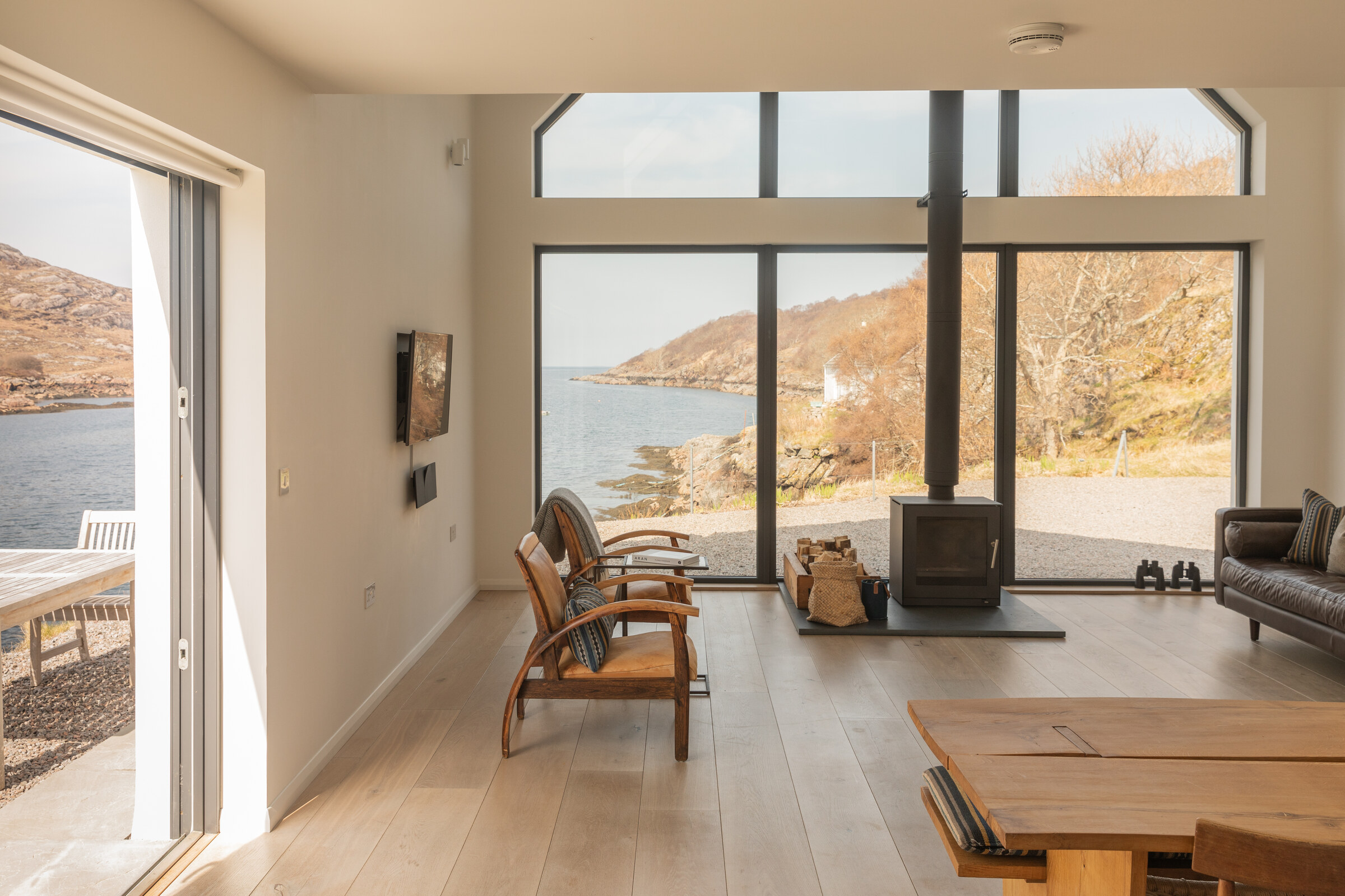 The Net Store’s open-plan room, its glass door open to the terrace and the tall gable window looking over the bay.