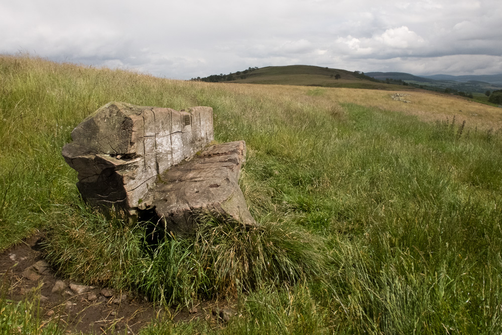 A concrete block on the grassy hill ground above Balnahard, the Finzean hills beyond.