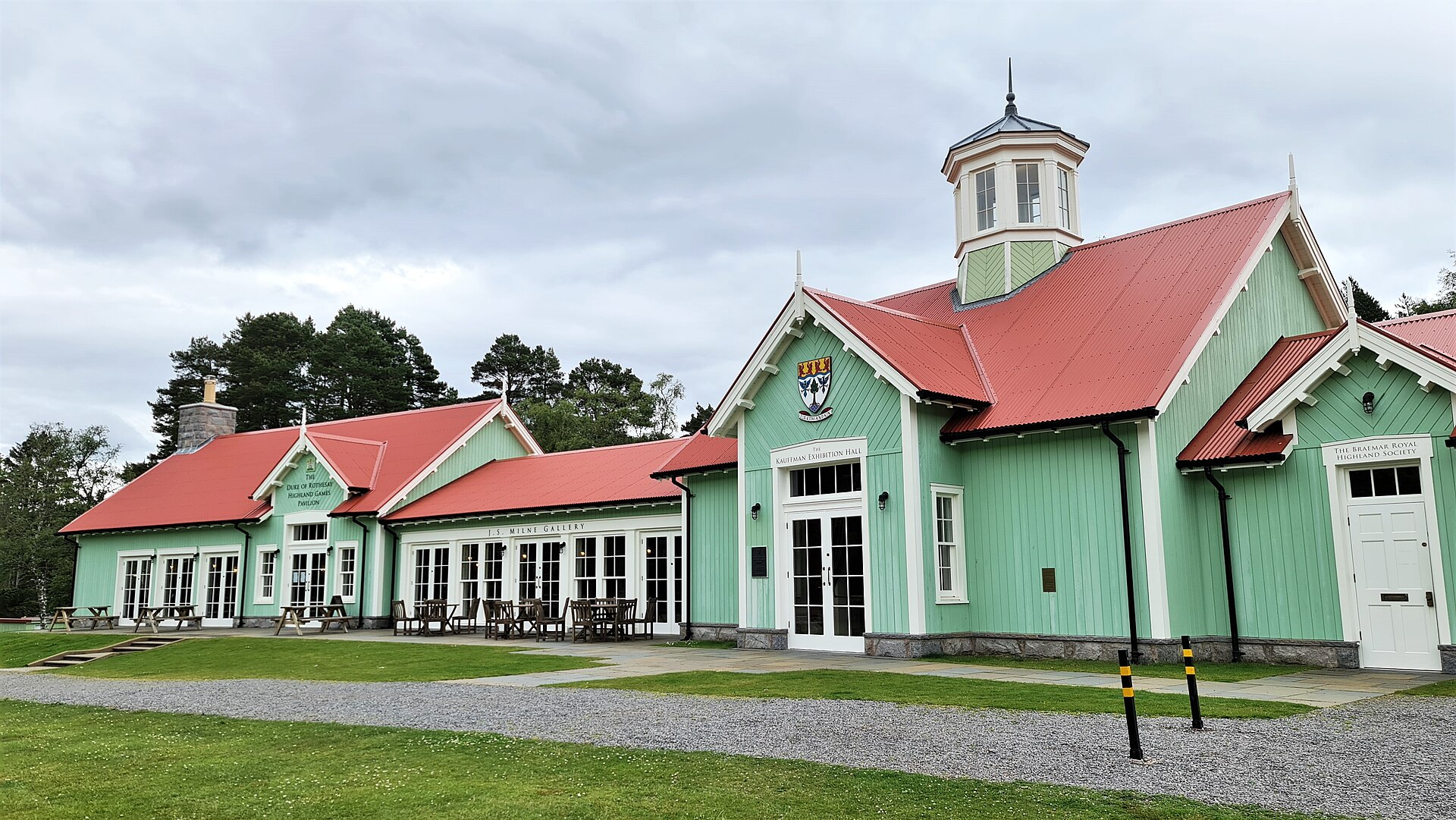 The Duke of Rothesay Highland Games Pavilion at Braemar, green timber under red roofs and a white clock tower.