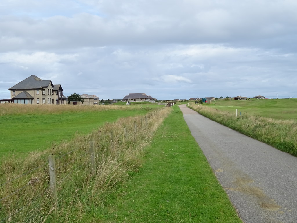 A road running between green fields beside the golf course at Inverallochy.