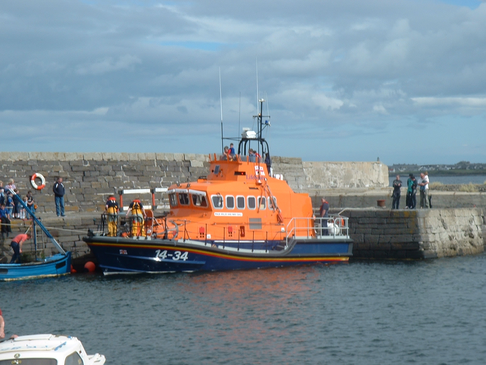 The orange lifeboat moored in Sandhaven harbour below the village.