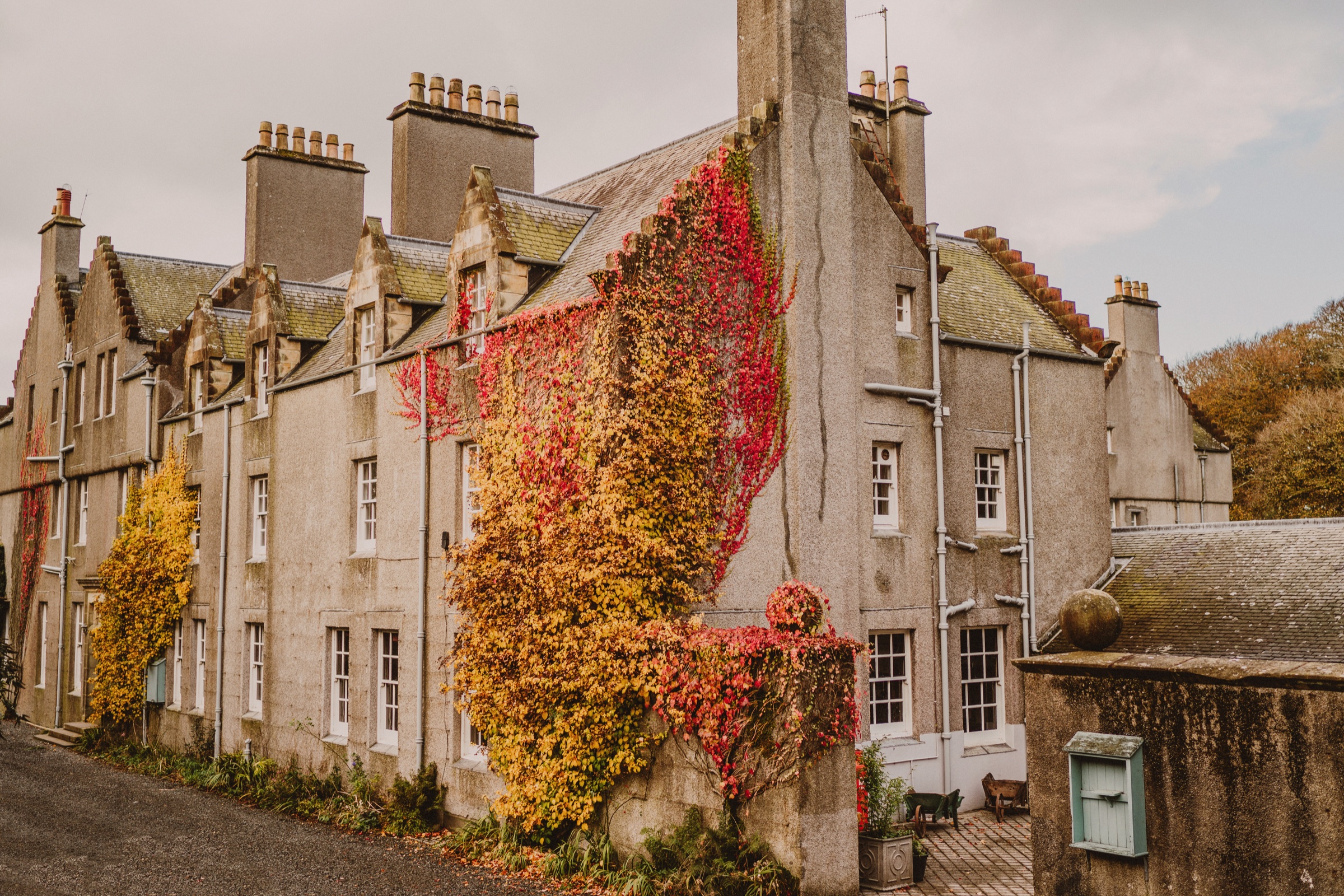 Dunskey House, the castle, in autumn, red and gold ivy over its walls, chimneys and gables.