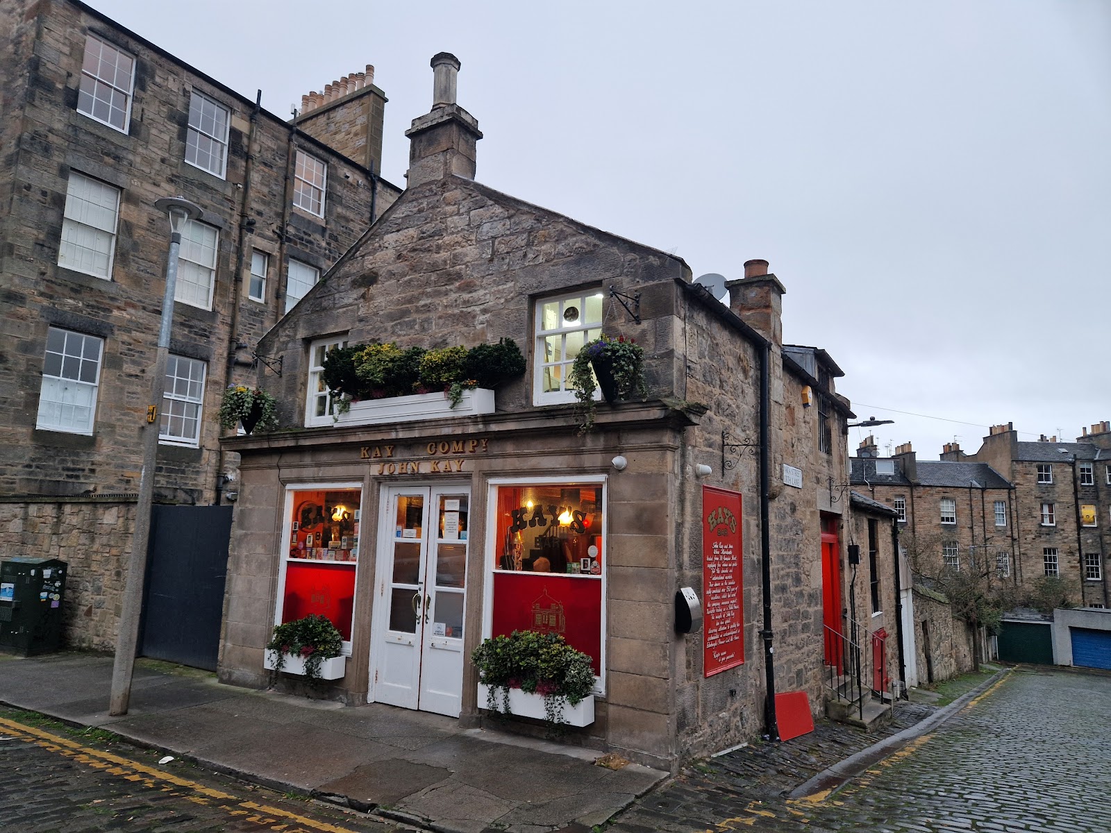 Kay's Bar on Jamaica Street West, a small stone building with red windows, white doors and John Kay lettered above them, on a cobbled lane.