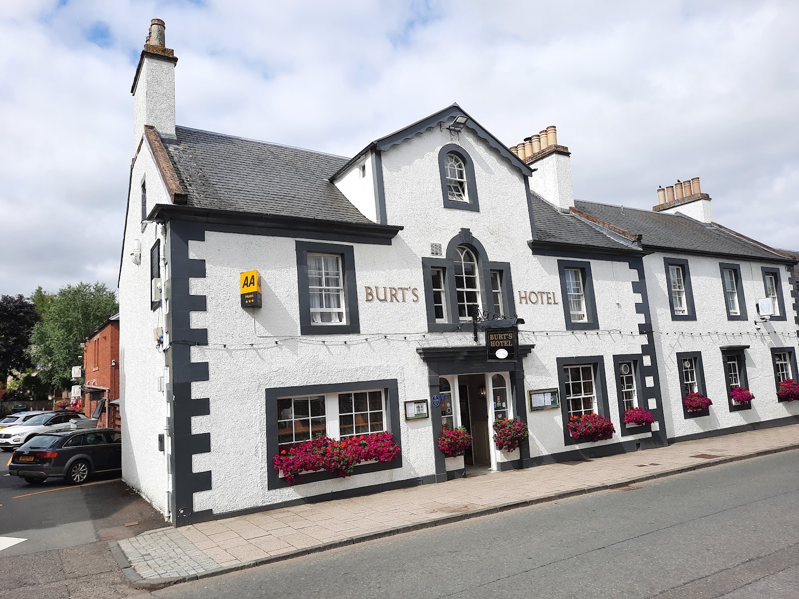 Burts Hotel in Melrose, a white-painted 18th-century inn with black window surrounds and red window boxes.