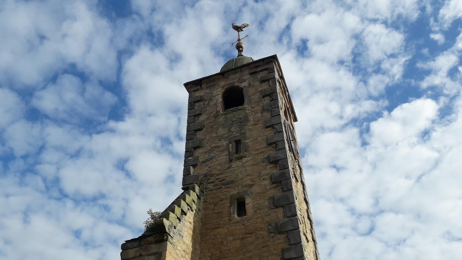 The stone belfry of Clackmannan's old tolbooth against a blue sky.