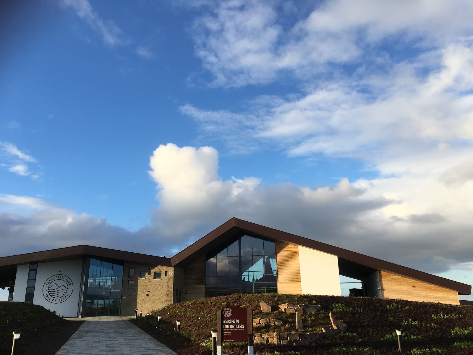 Modern angular building with sign reading "Welcome to Lagg Distillery, Isle of Arran