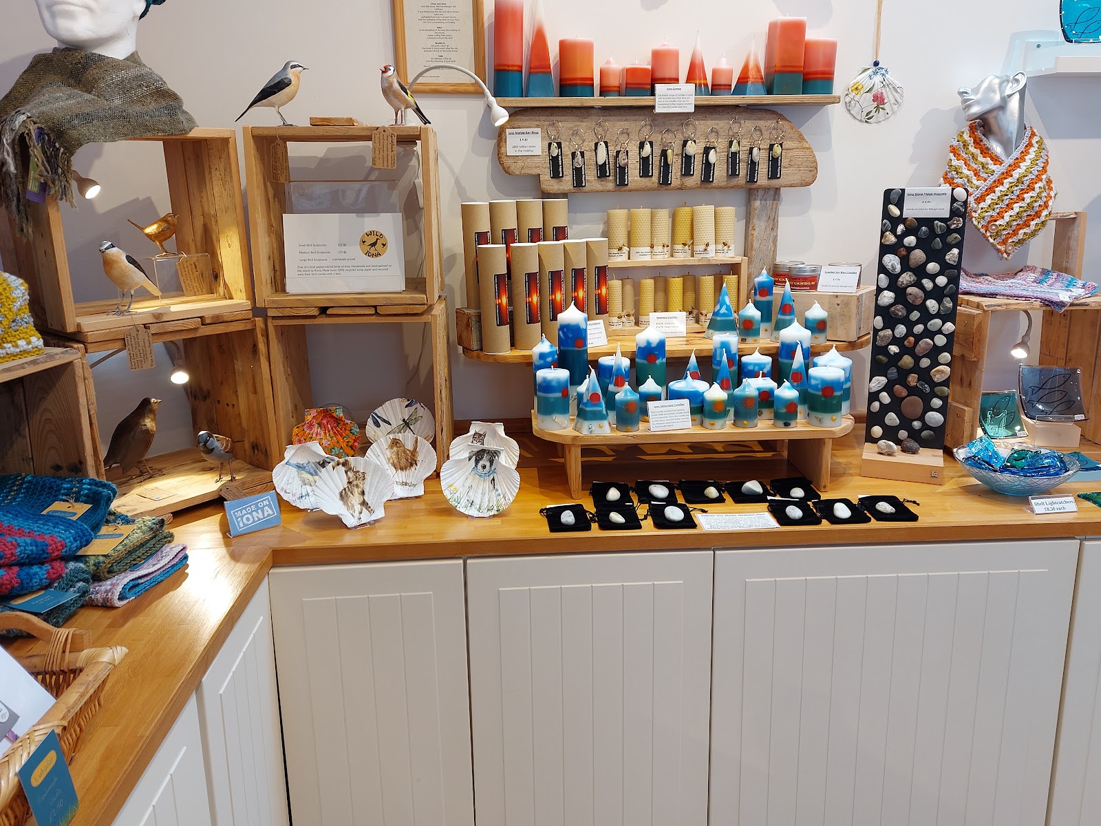 Inside Oran Creative Crafts: shelves of candles, glass and gifts on a wooden counter.