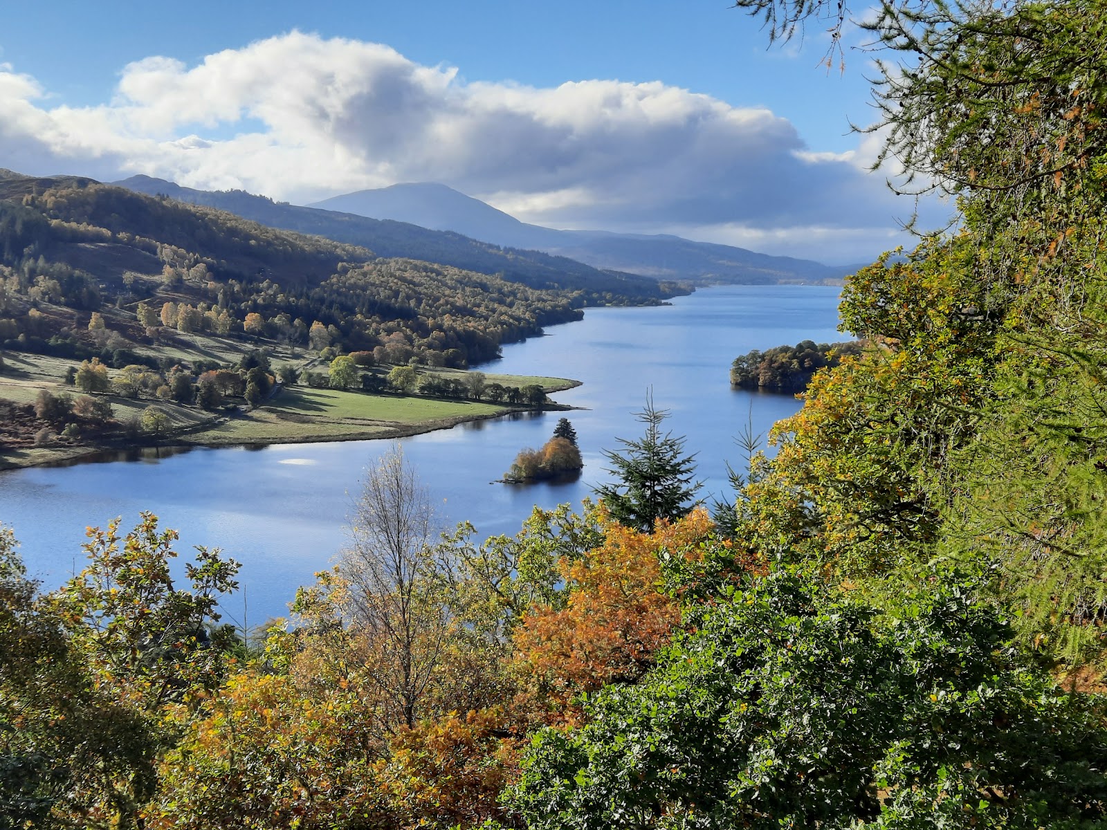 Loch Tummel stretches between wooded hills, framed by autumn leaves at Queen's View