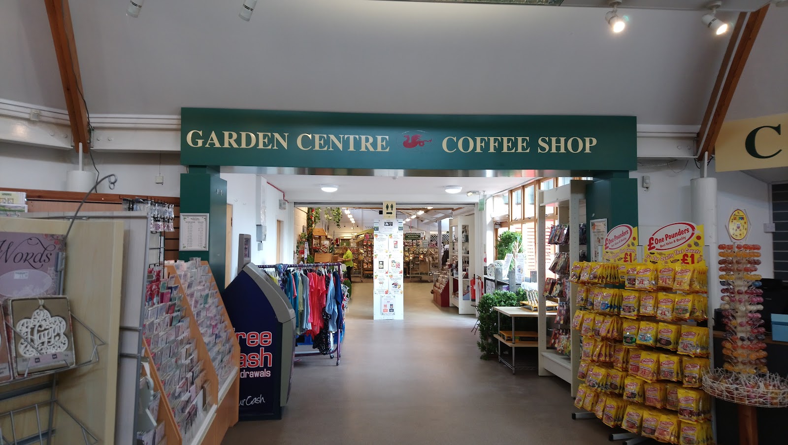 Green sign reading "Garden Centre Coffee Shop" above a shop entrance with £1 pounder displays