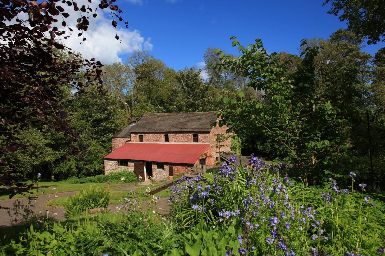 The red-roofed kiln at Barry Mill in its wooded dell.