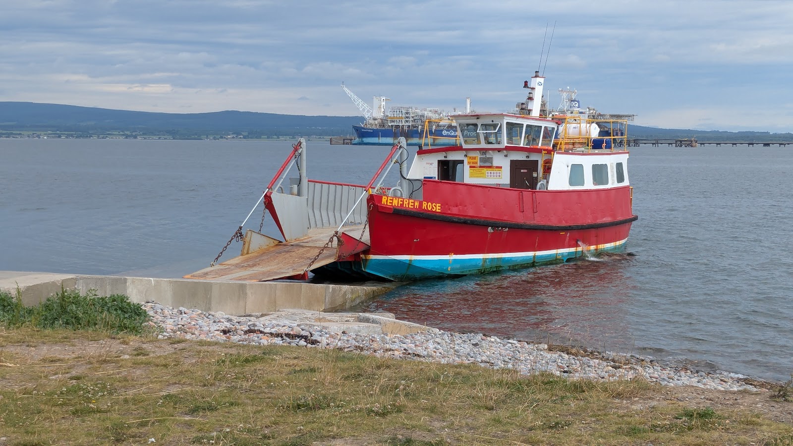 The Renfrew Rose ferry docks at a slipway, an oil rig visible across the firth