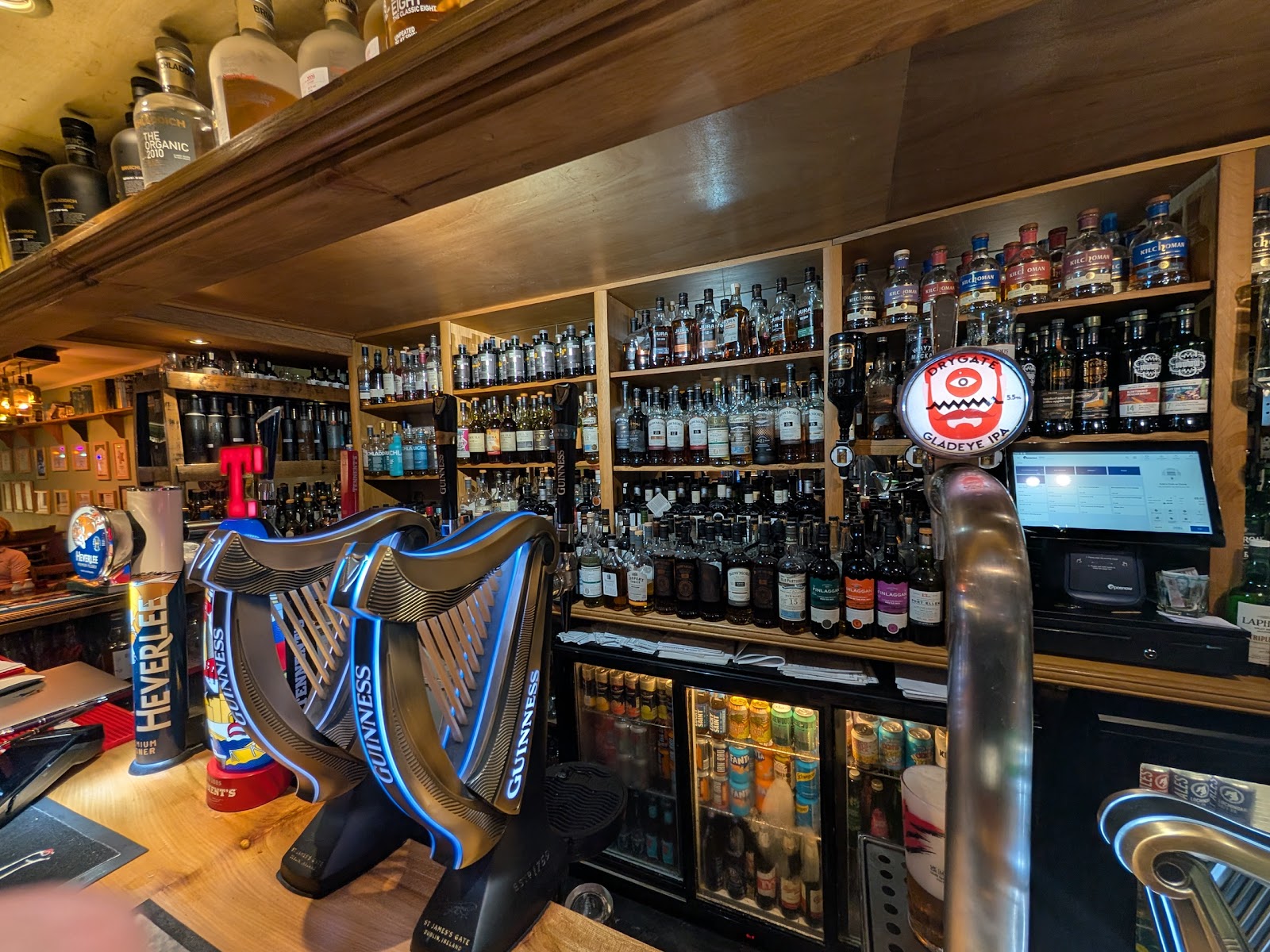 Beer taps and shelves of bottles behind the bar at the Ballygrant Inn.