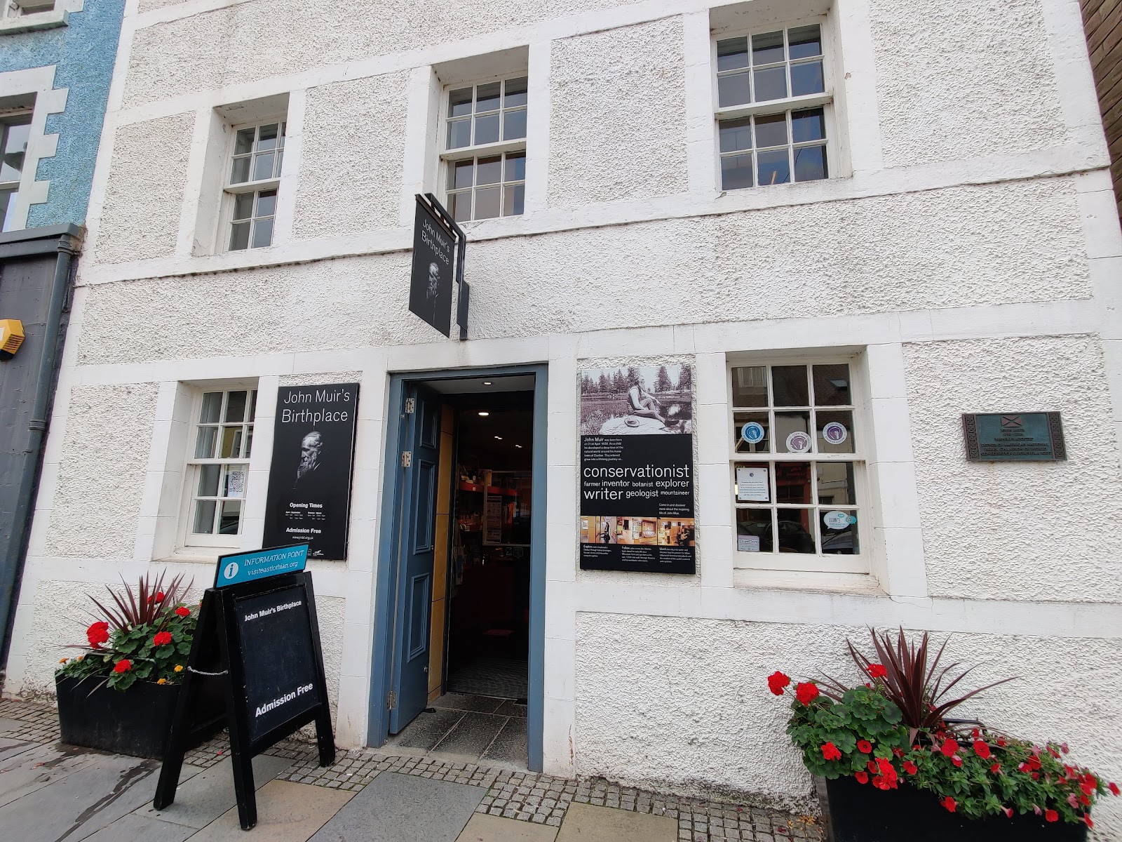 John Muir's Birthplace on Dunbar High Street, a white-harled house with flowers by the open door.