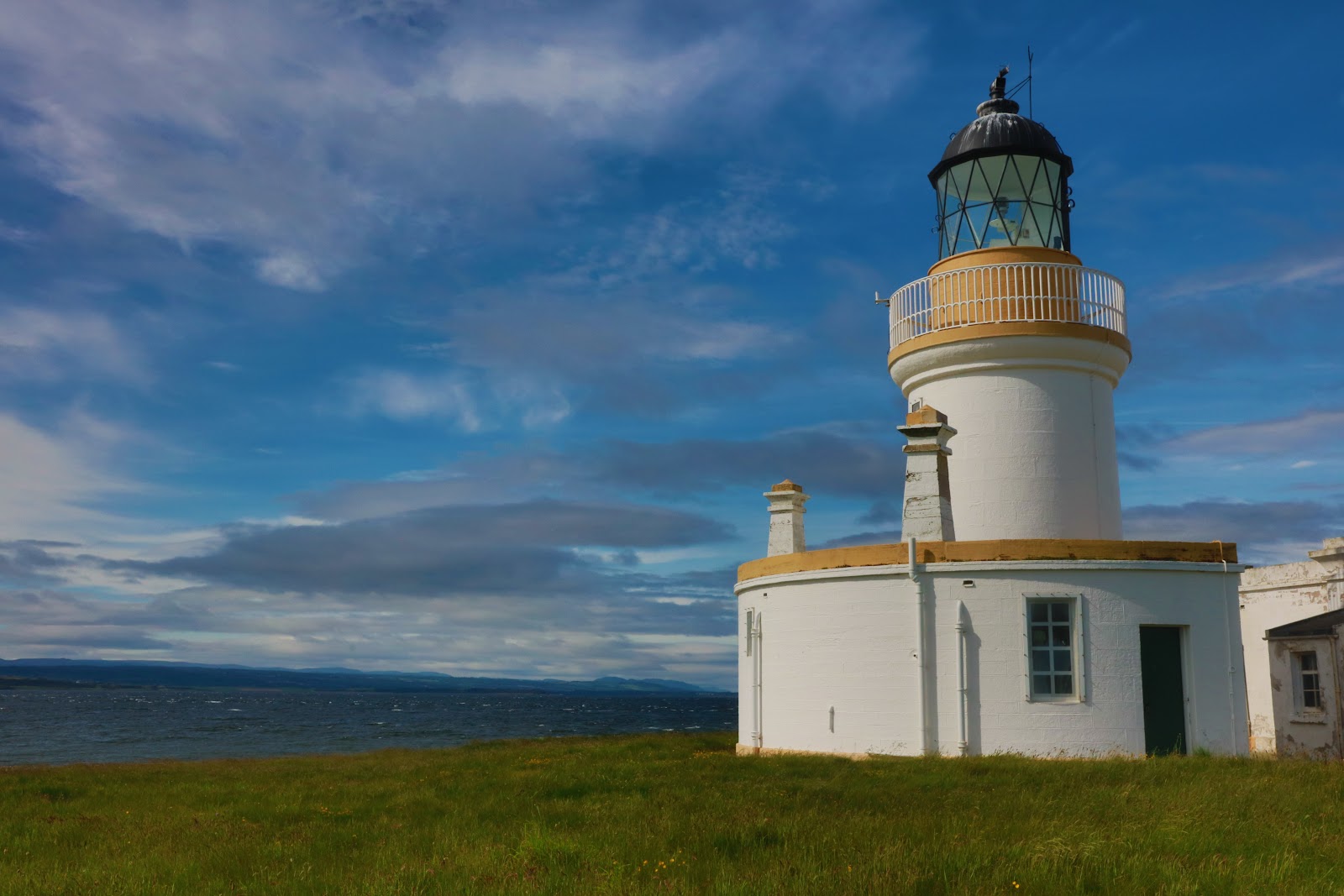 White lighthouse with black lantern room overlooking the Moray Firth