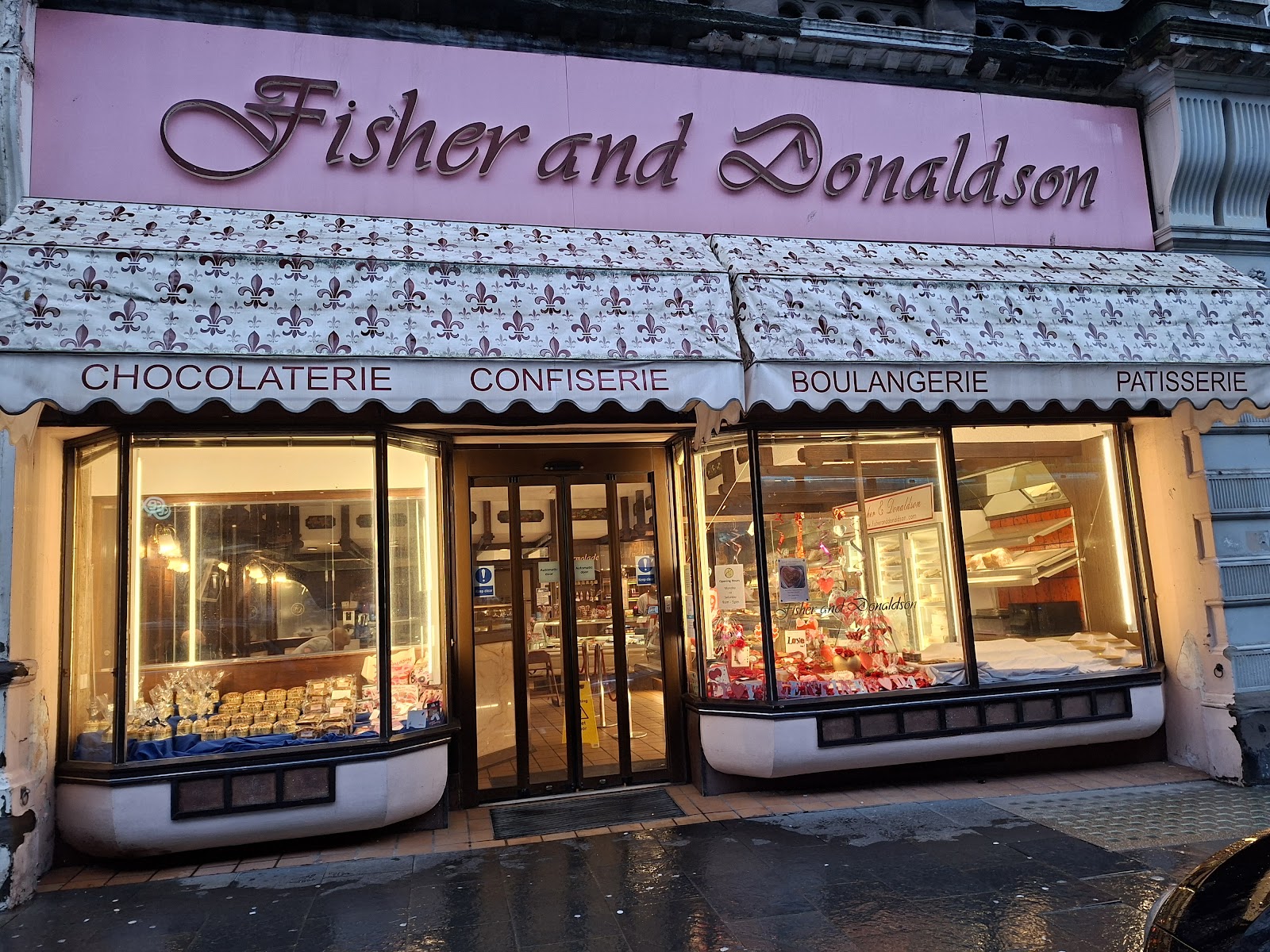Fisher and Donaldson's pink shopfront with chocolaterie and patisserie signs.