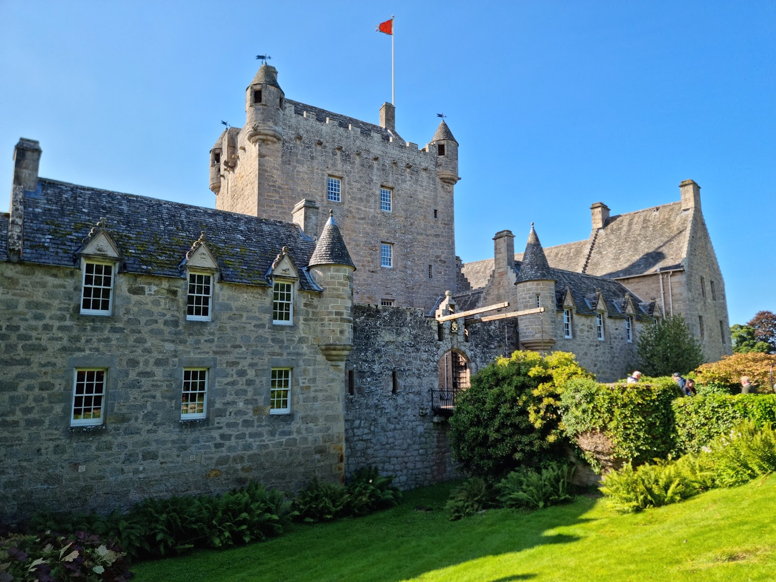 Turreted castle with drawbridge entrance and flag flying above the tower