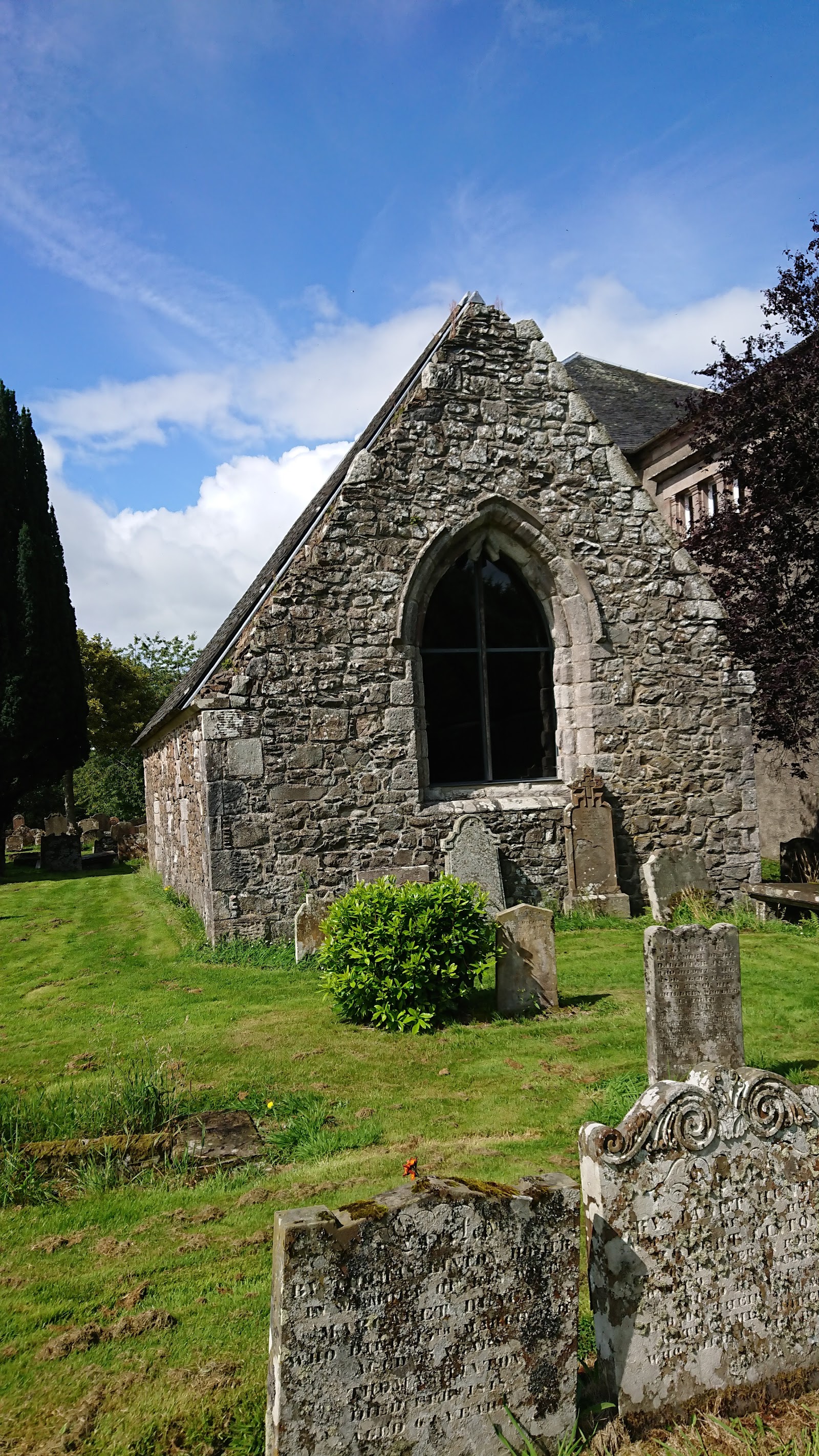 The roofless gable of St Mary's Chapel among the graves.