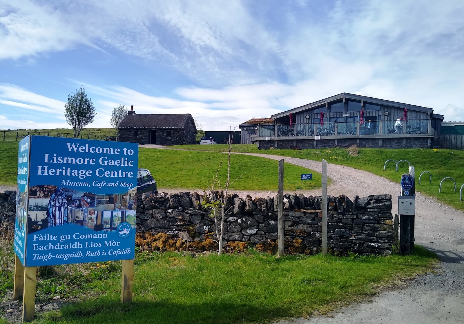 The heritage centre's sign and its grass-roofed building.