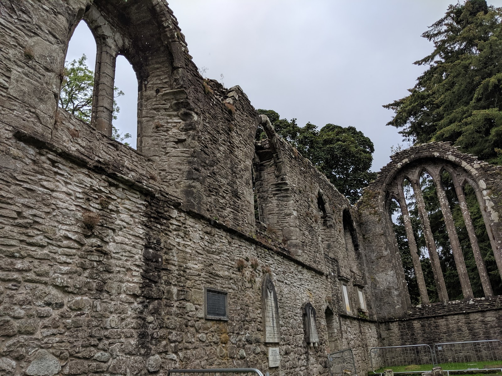 The tall roofless walls and arched windows of the priory church.