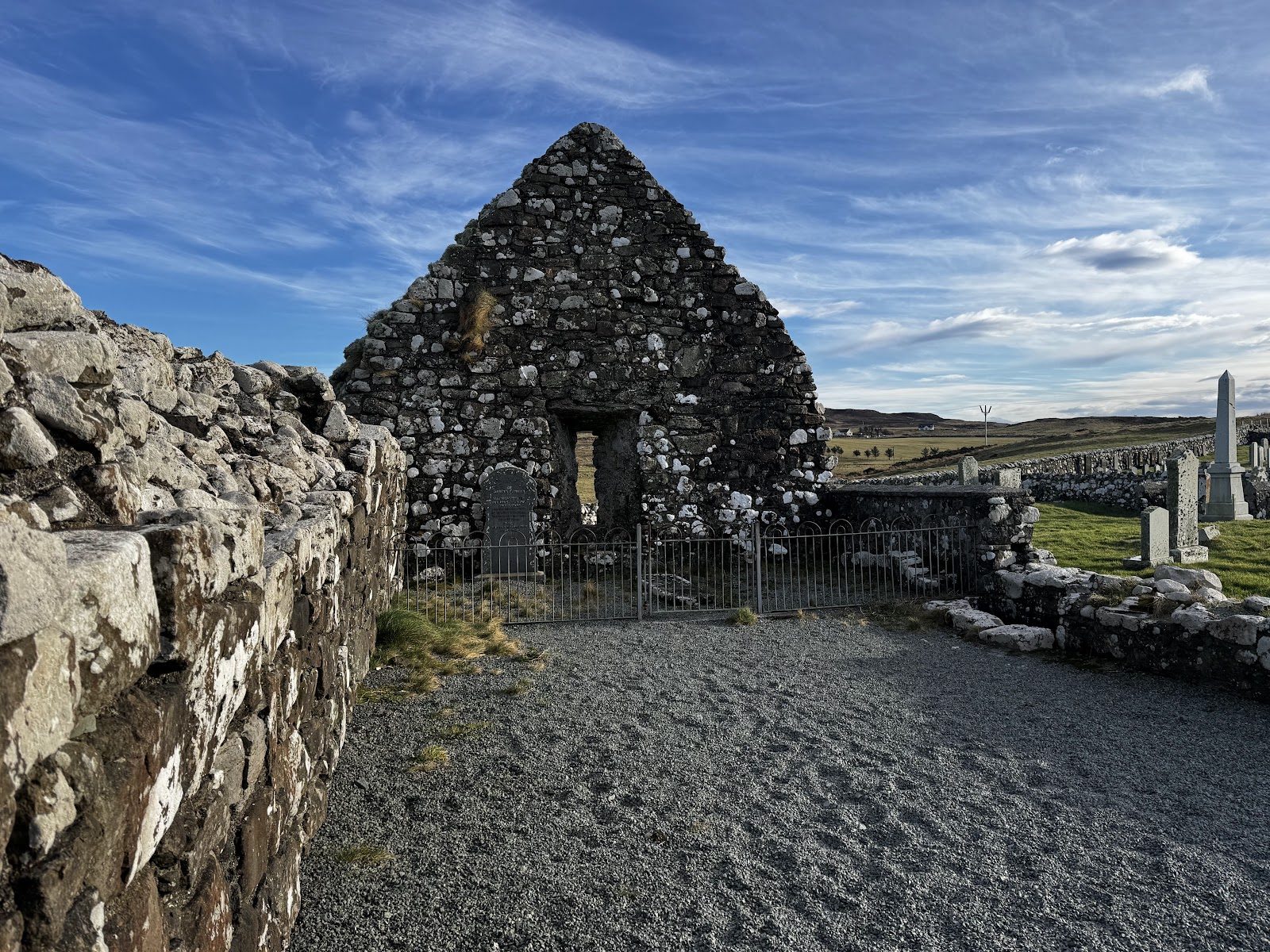 The church ruin inside its walled graveyard.